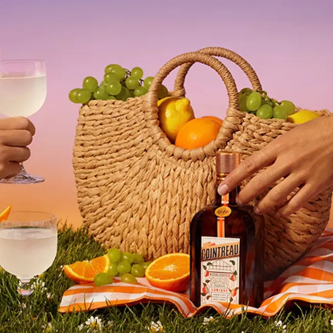 A Cointreau bottle in a summer picnic setting