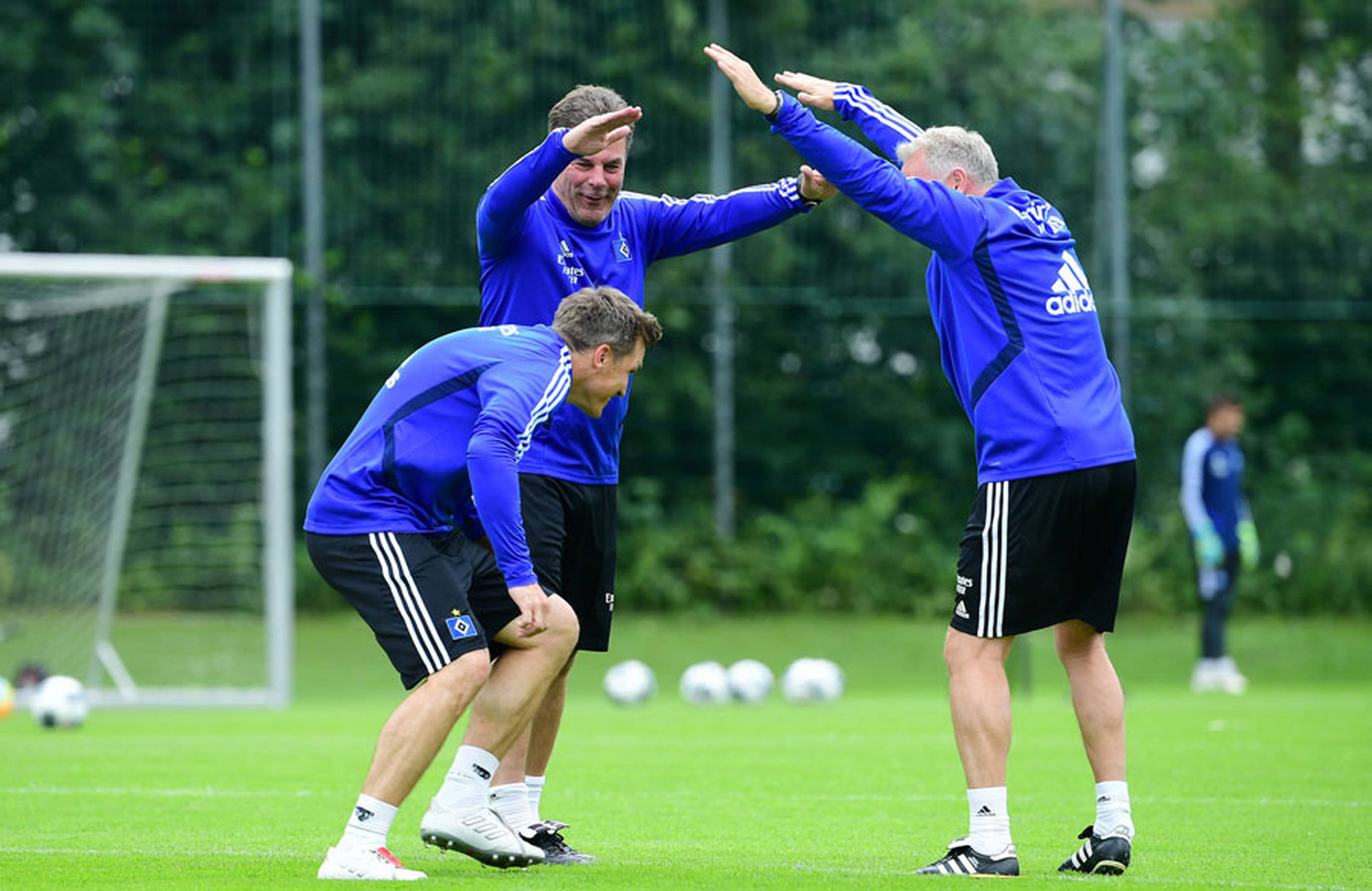 Dieter Hecking und Dirk Bremser halten die Arme hoch und Tobias Schweinsteiger läuft unter durch. 