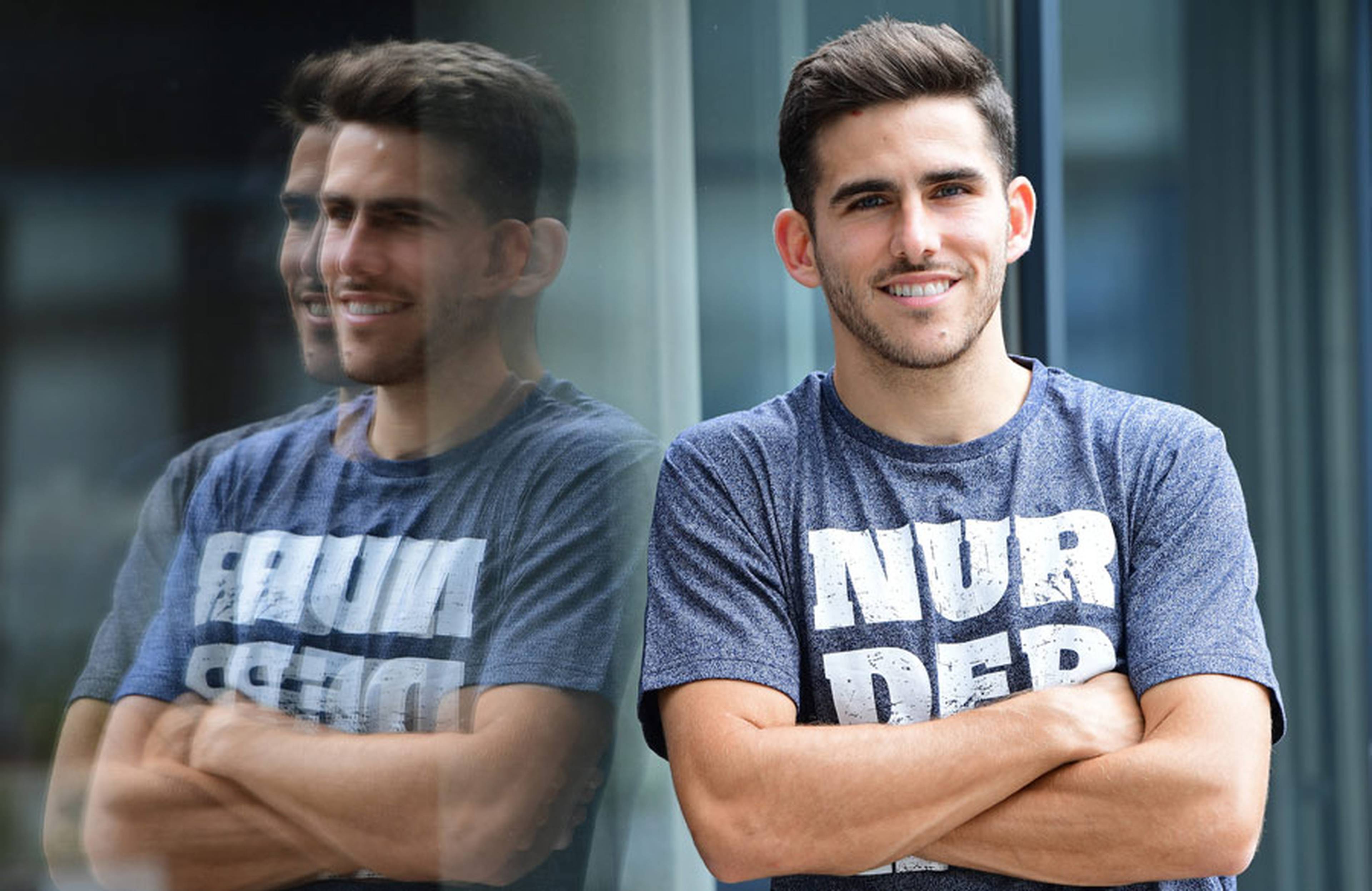 Jairo lehnt an einer Fensterscheibe. Sein Spiegelbild ist im Fenster zu sehen.