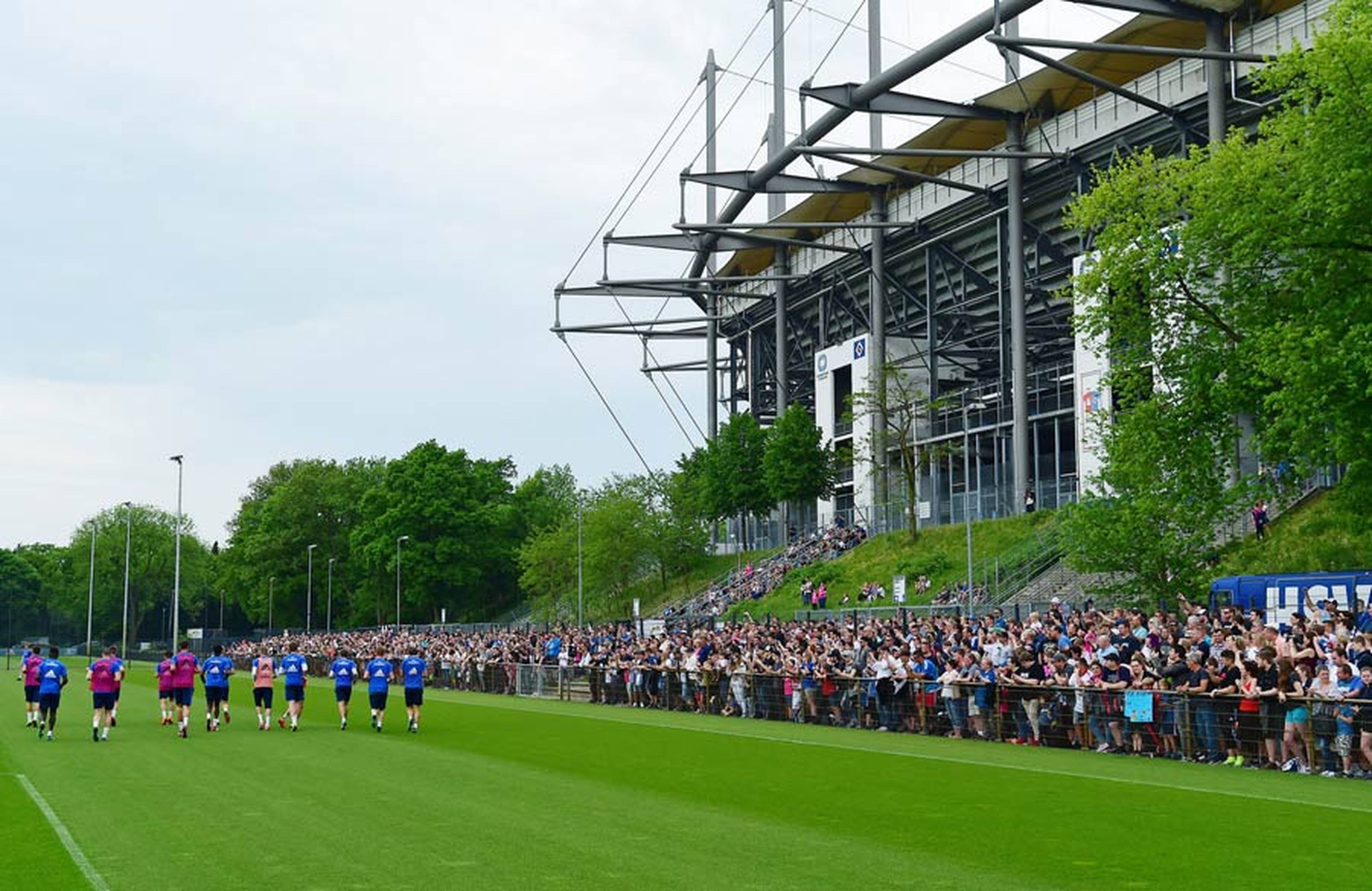 Rund 2.000 Fans stehen am Trainingsplatz. Im Hintergrund ist das Volksparkstadion zu sehen.