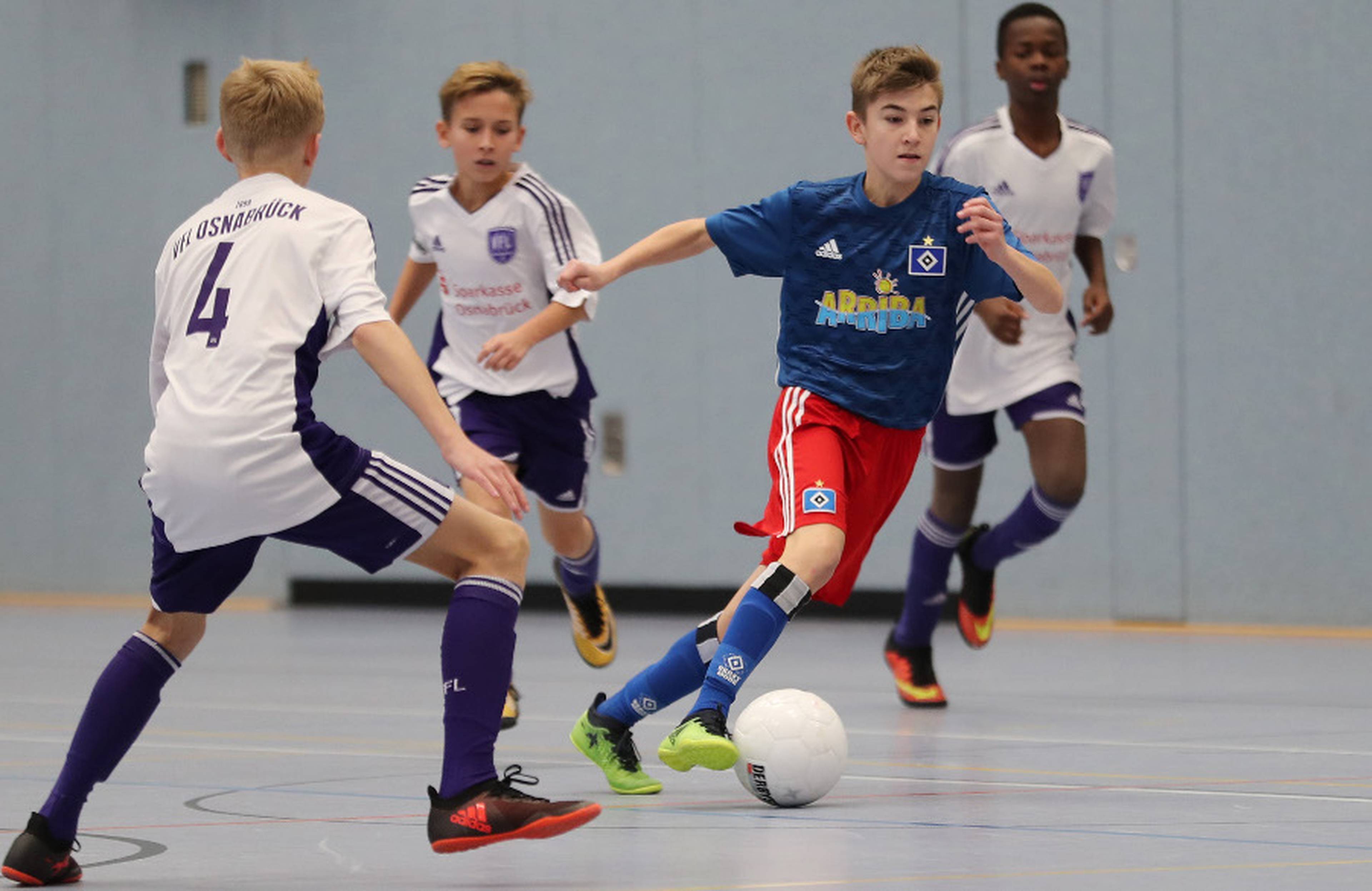 Der U15-Kicker des HSV setzt sich in der Halle gegen seine Gegenspieler durch