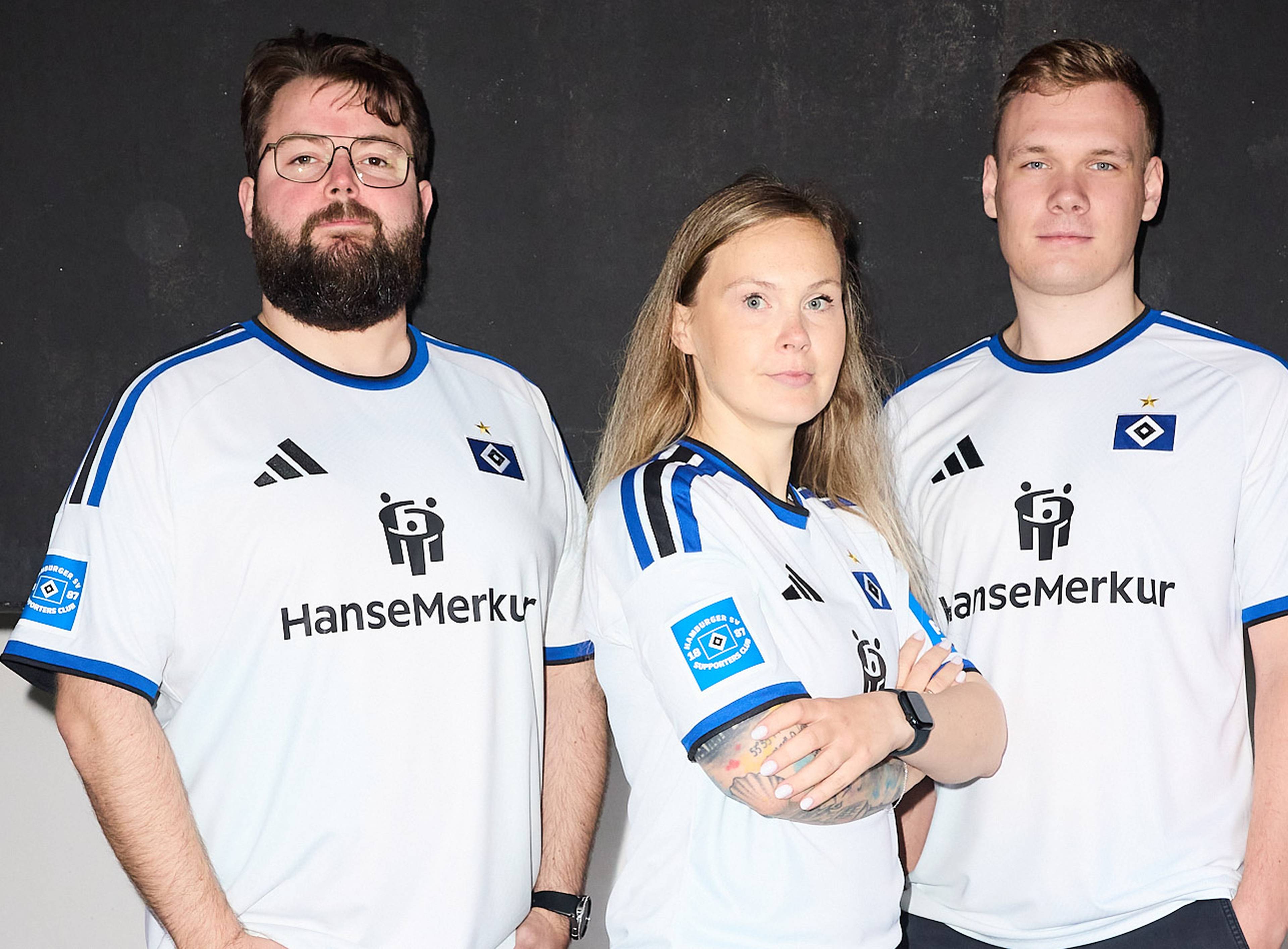 Three people wearing matching white sports jerseys with blue accents and sponsor logos, standing against a dark background.