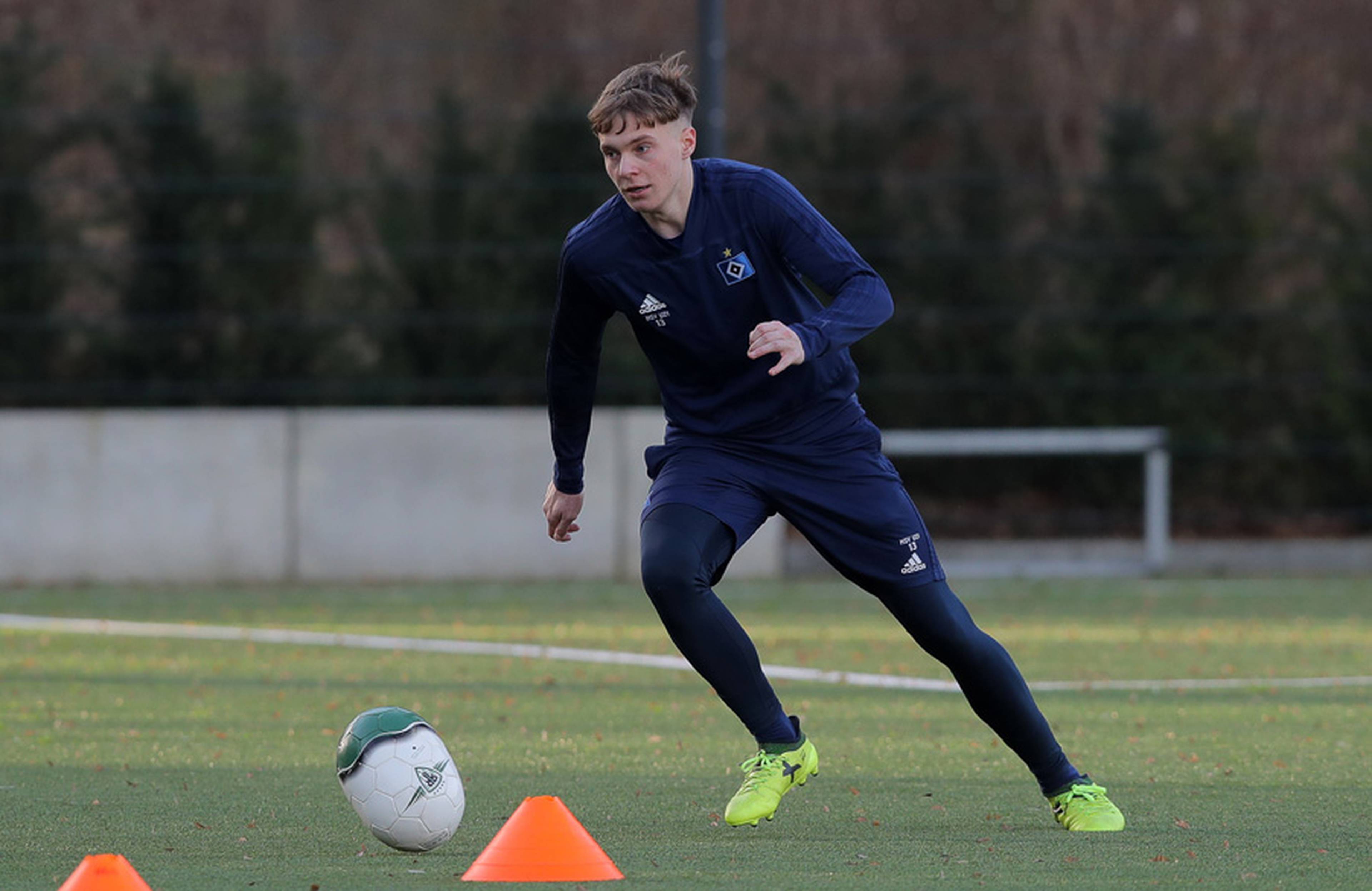 Niklas Schneider dribbelt mit einem eiförmigen Ball.