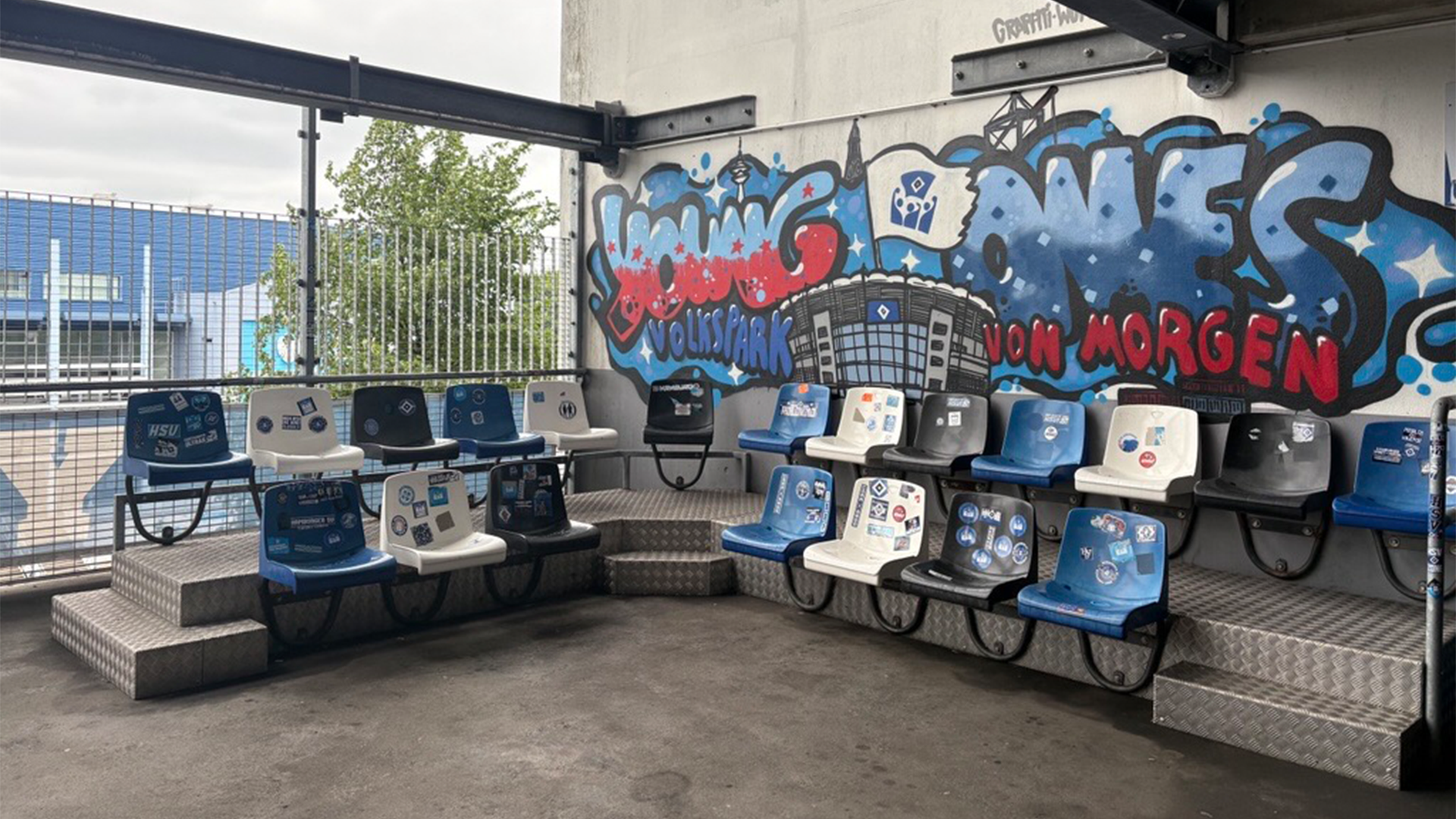Ein Treffpunkt im Volksparkstadion mit einem Young Ones Graffiti an der Wand.