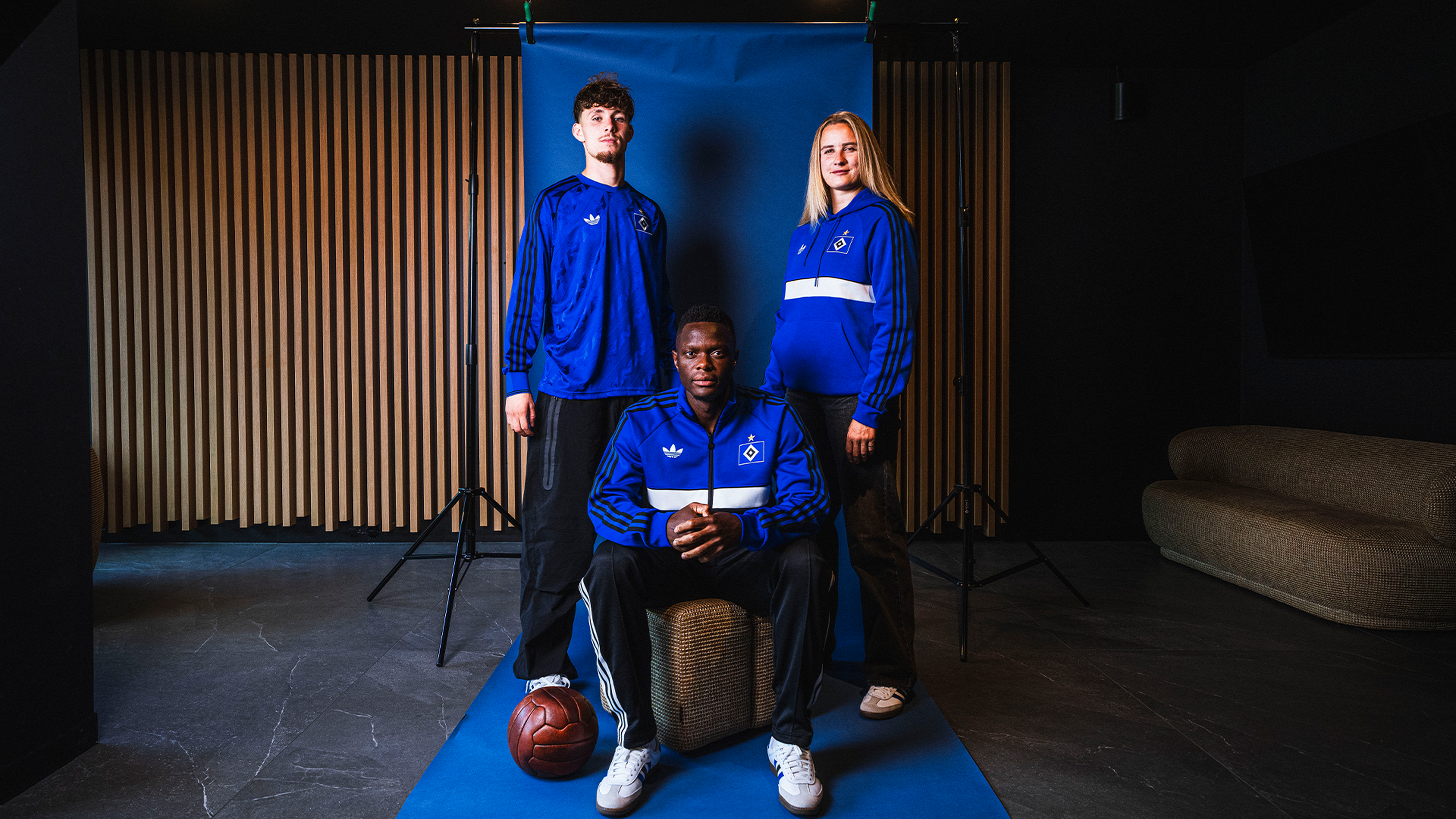 Spieler und Spielerin des HSV posieren in adidas Klamotten.