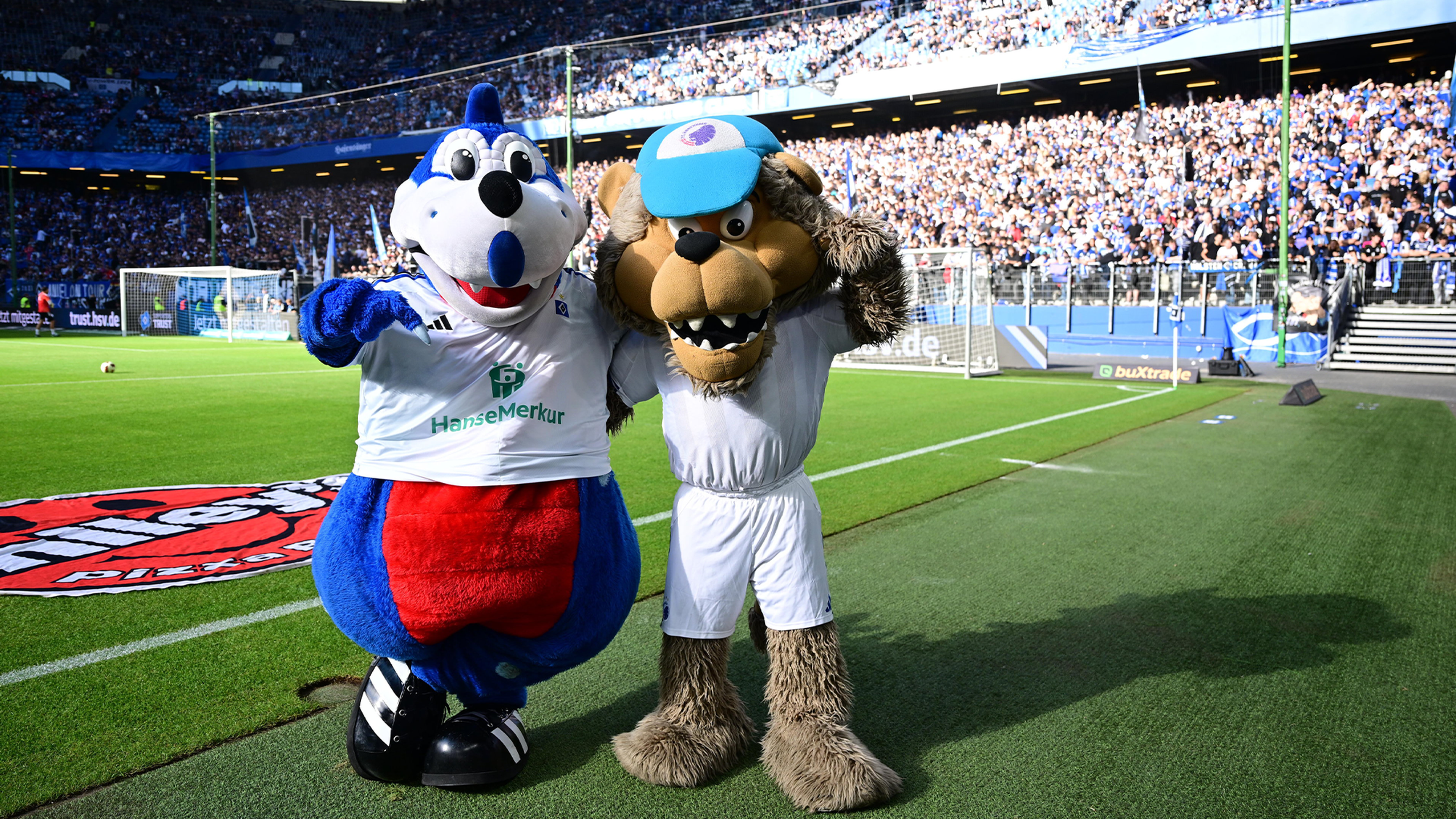 Maskottchen Dino Hermann und Leo vom FC Kopenhagen posieren auf dem Rasen.