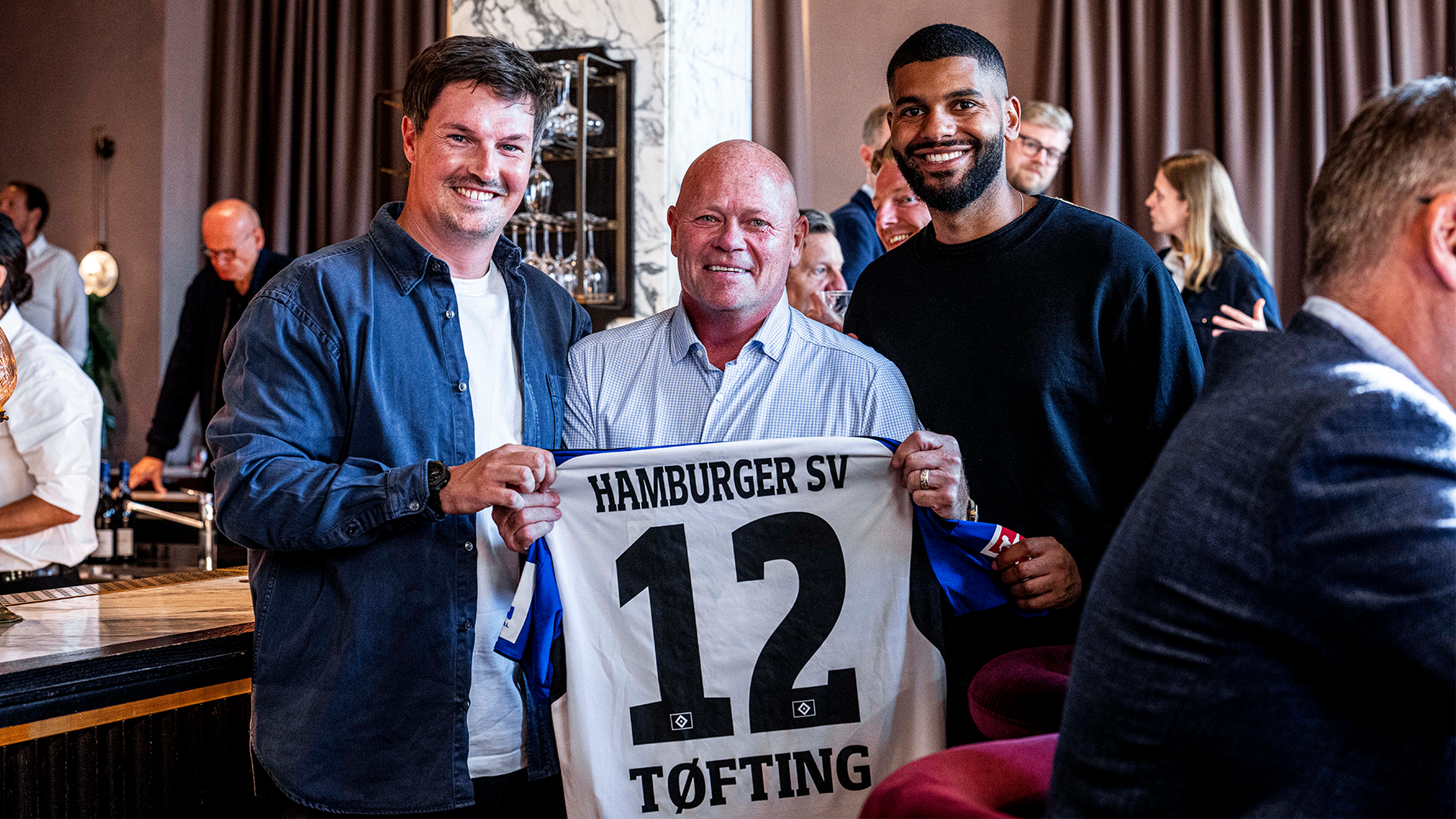 Merlin Polzin zusammen mit Stig Töfting und einem personalisiertem Trikot.