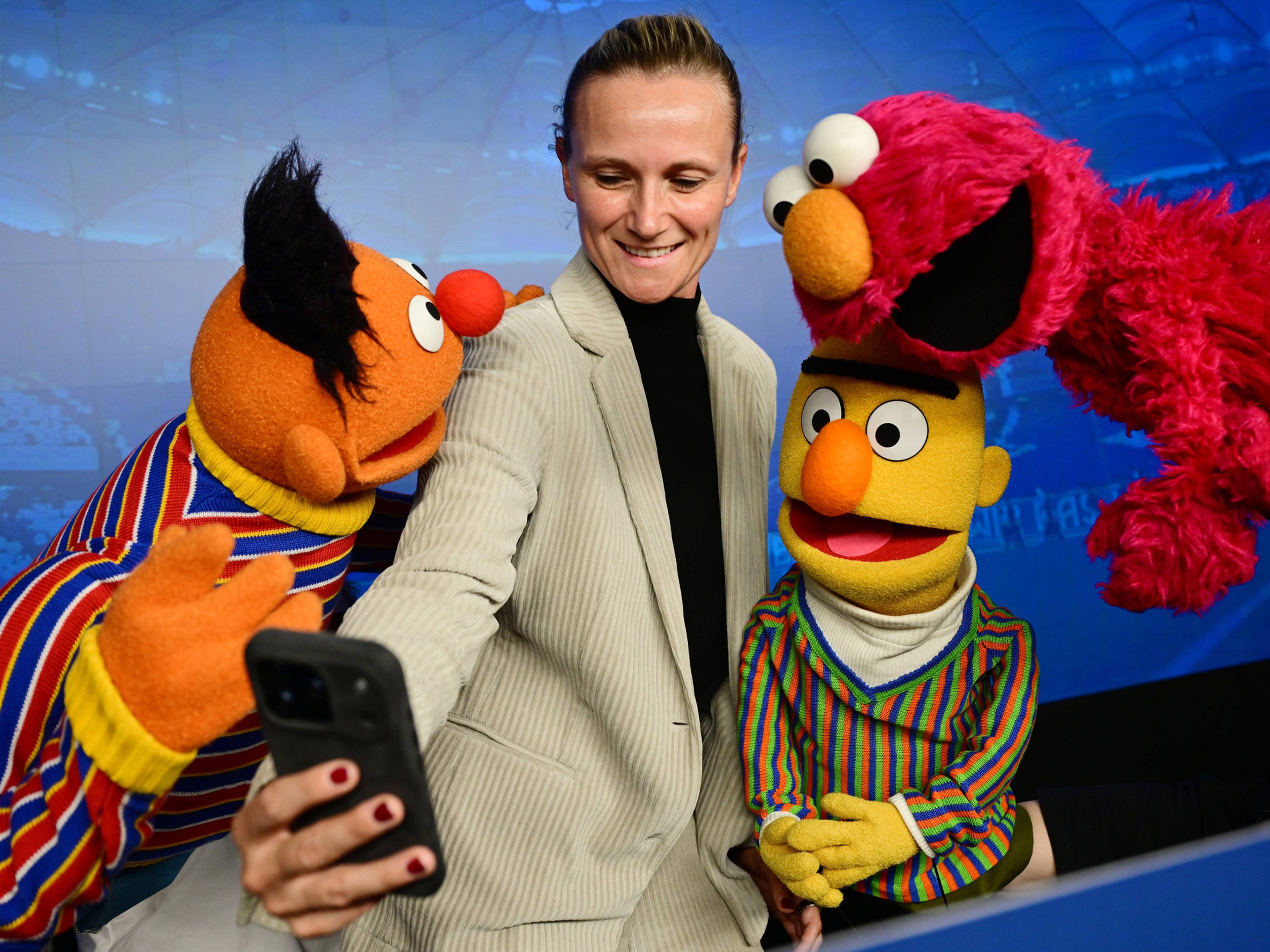 Kathleen Krüger macht ein Selfy mit Ernie, Bert und Elmo
