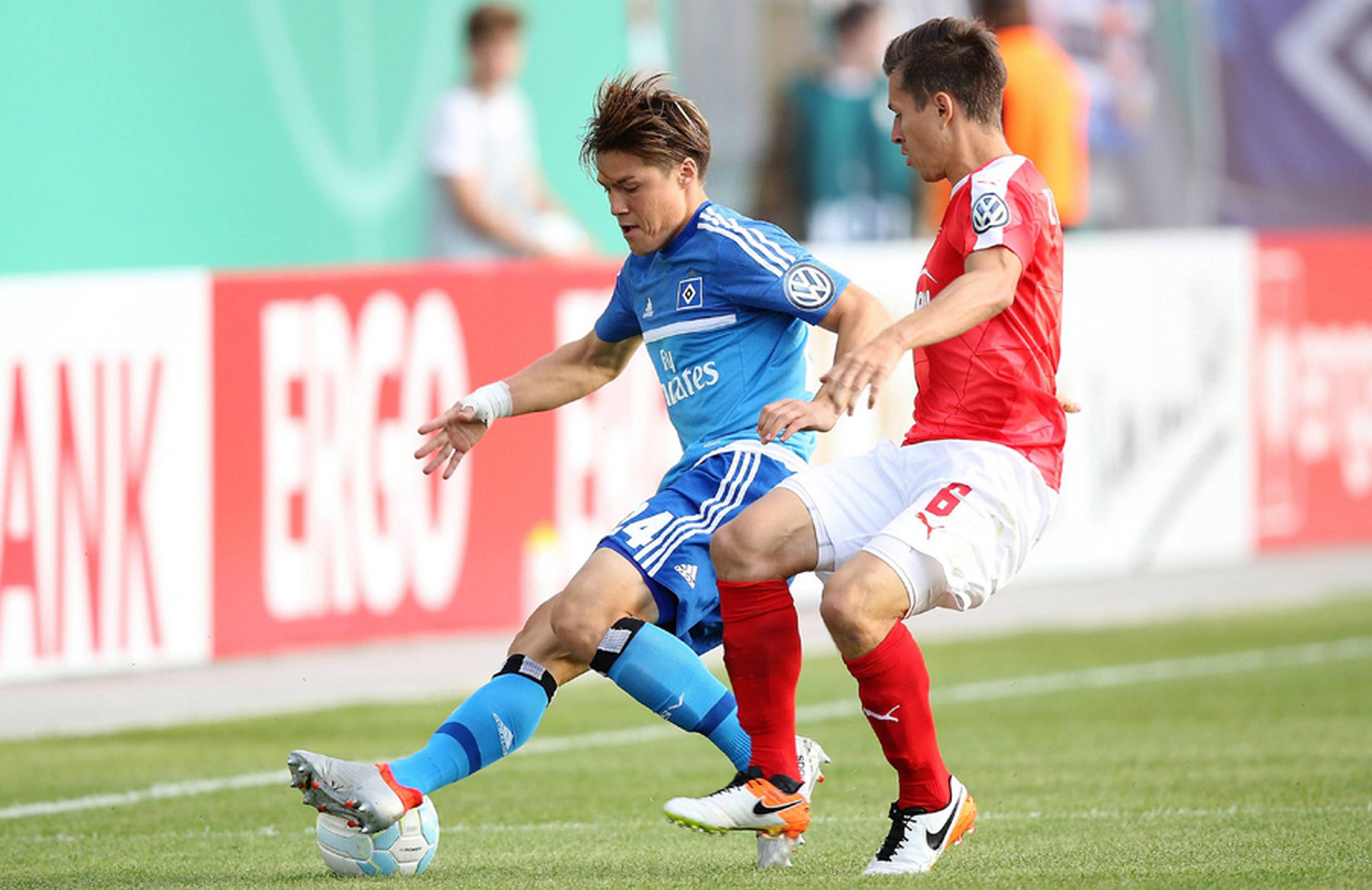 Gotoku Sakai schirmt im Zweikampf den Ball vor seinem Gegenspieler ab.