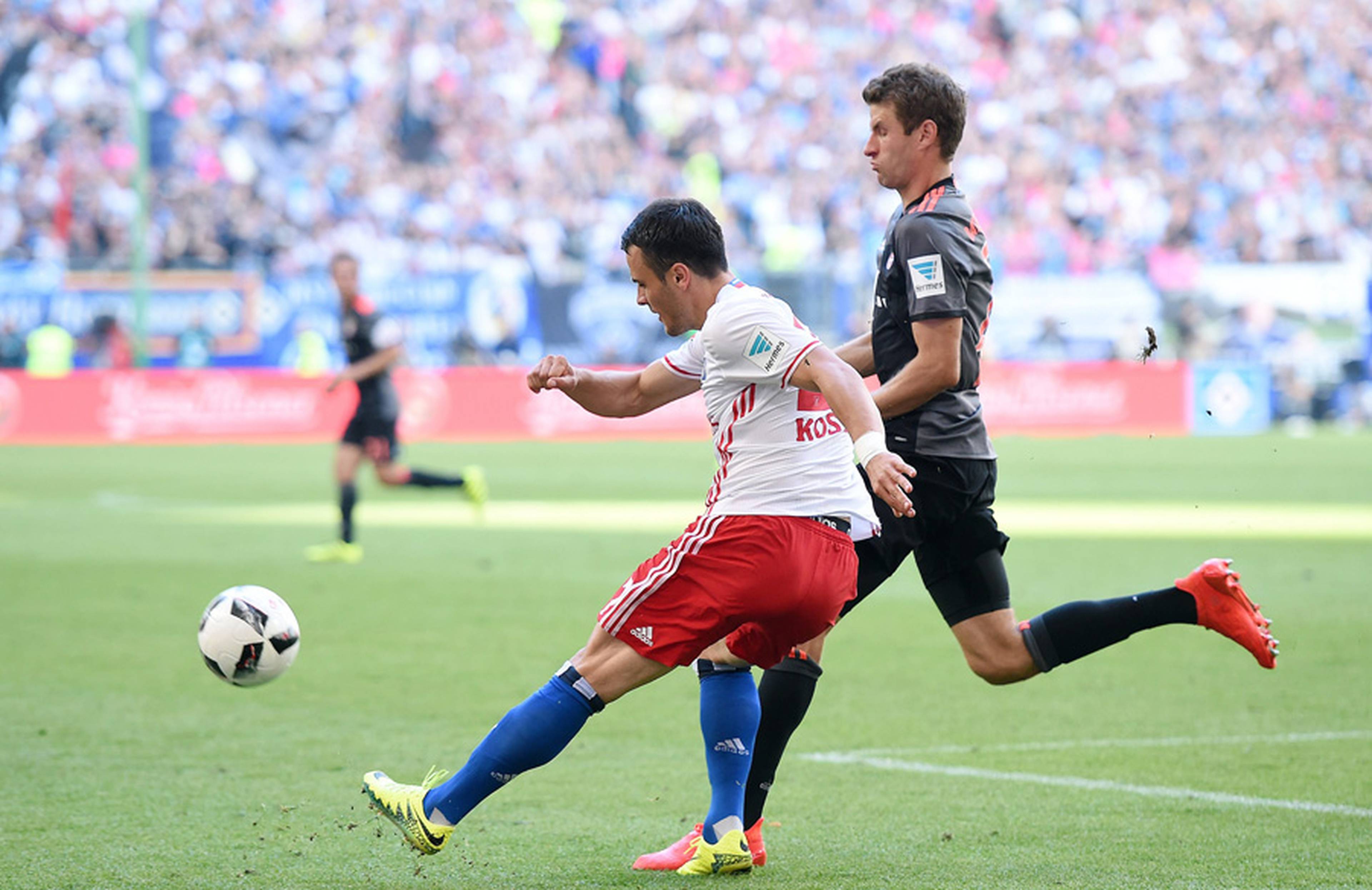 Filip Kostic crosses challenged by Thomas Müller.