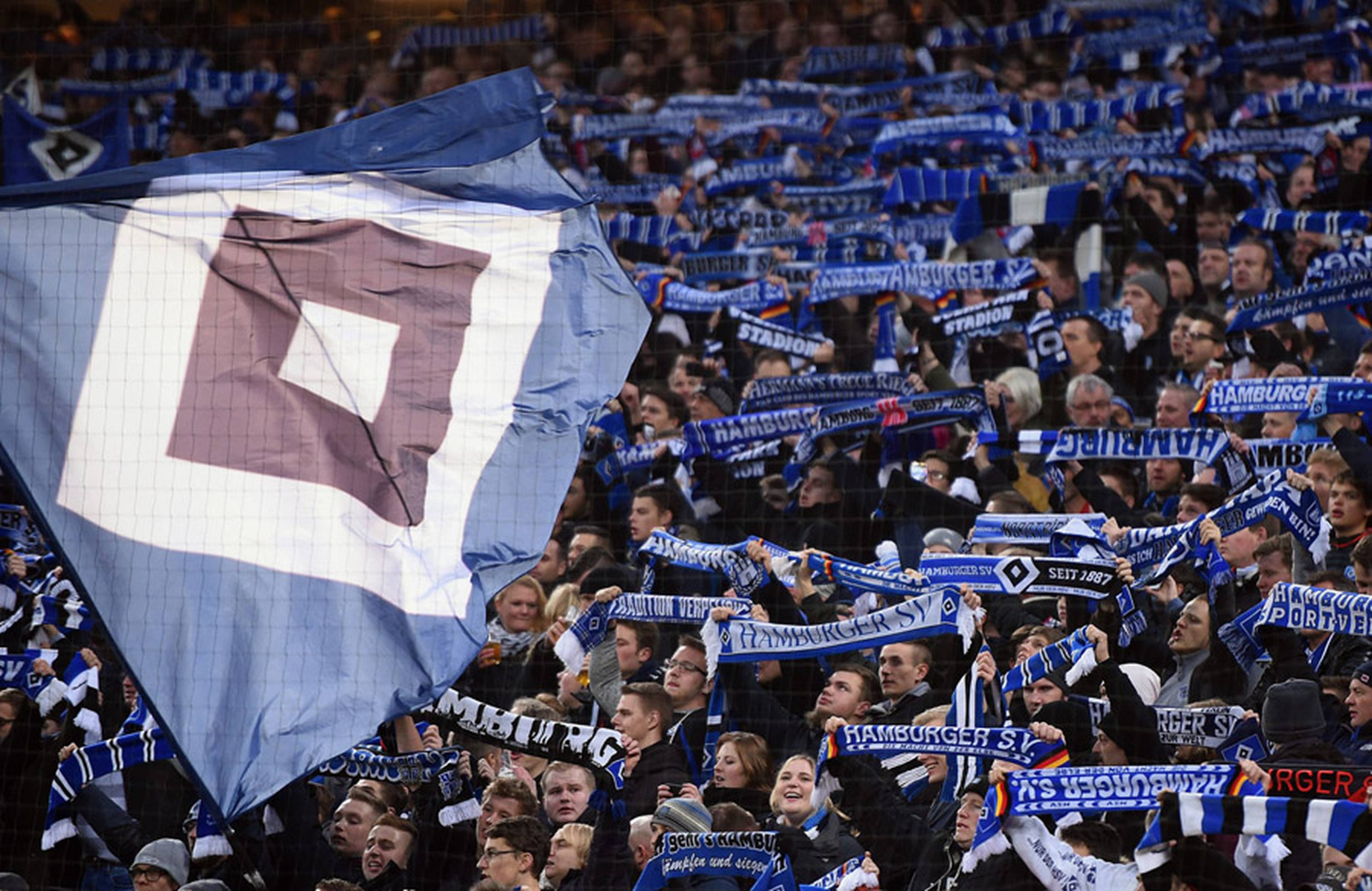 Die Fans auf der Nordtribüne schwenken Fahnen.