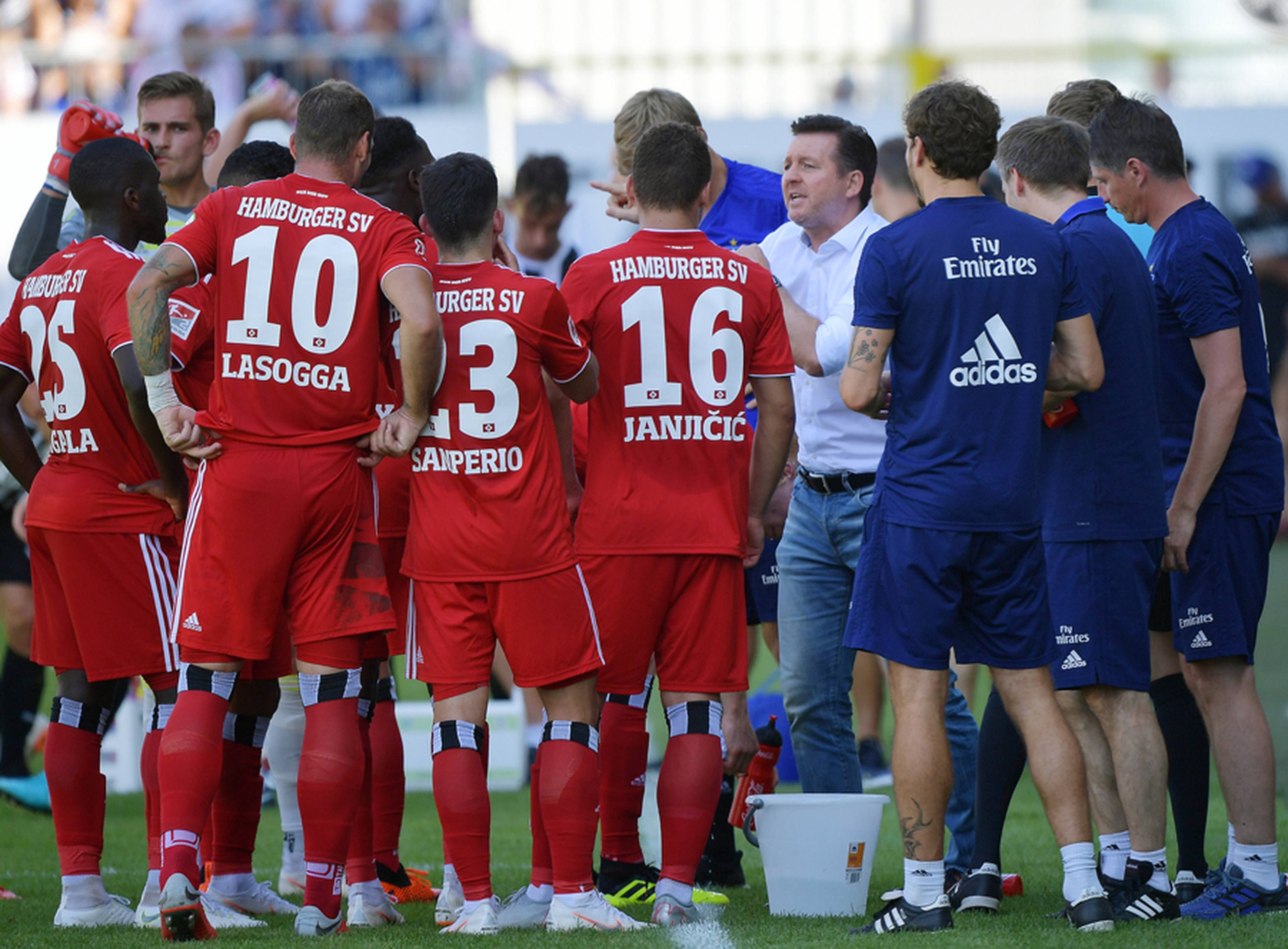 Christian Titz hat die Spieler nach dem Spiel in Sandhausen zu einem Kreis zusammengeholt und spricht zu ihnen. 