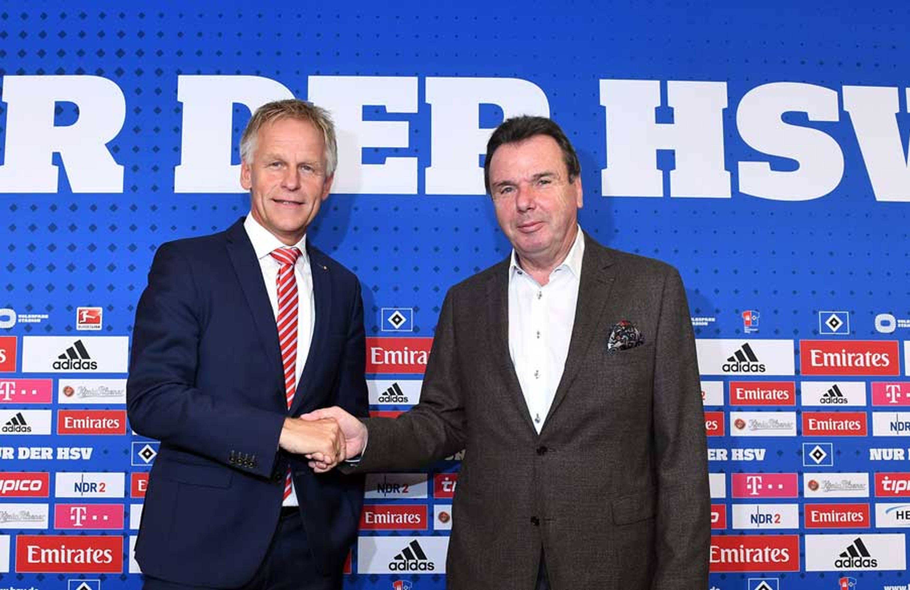 Heribert Bruchhagen und Jens Meier schütteln sich auf dem Podium die Hand. 