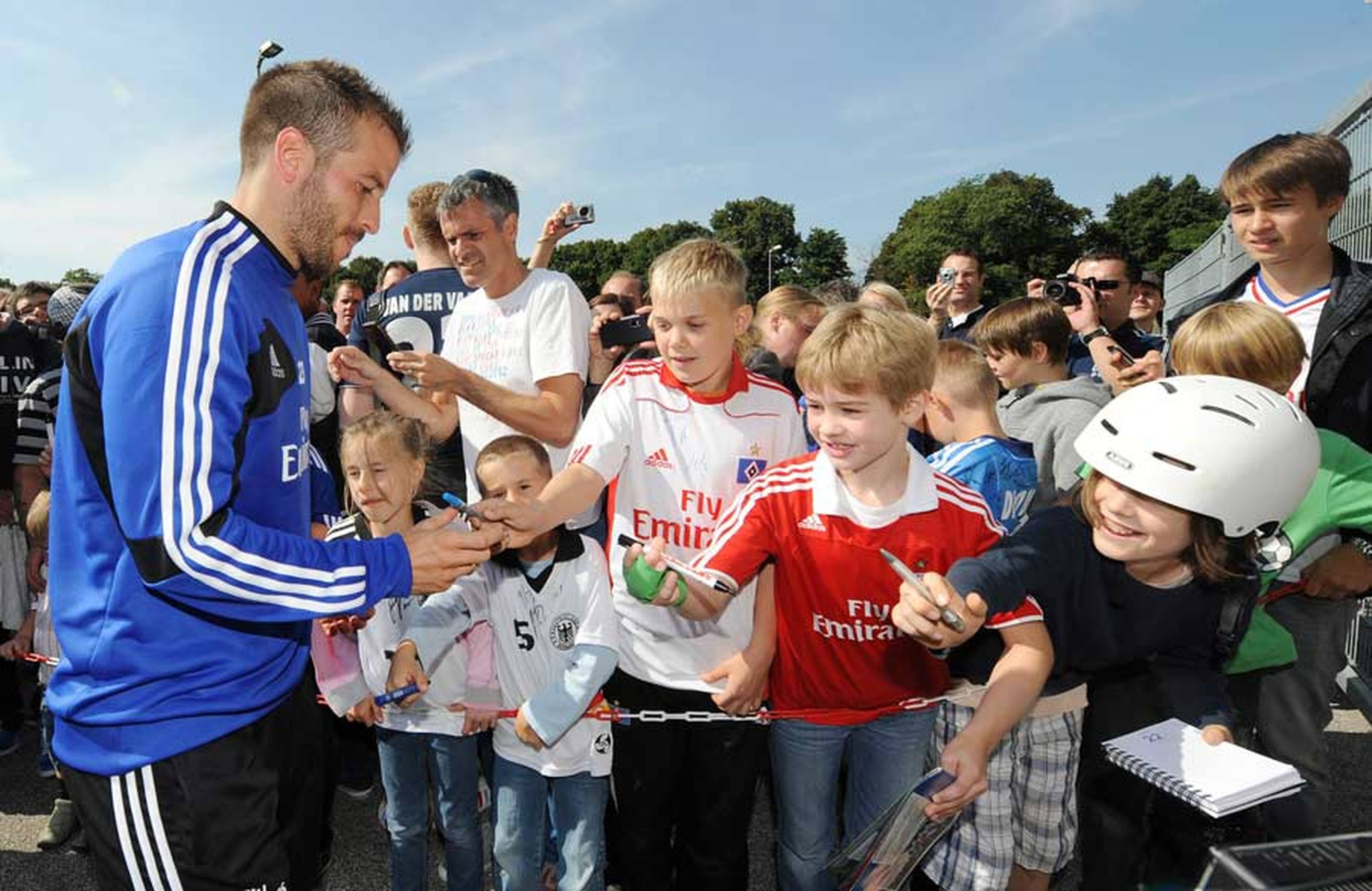 Rafael van der Vaart schreibt bei den Fans Autogramme. 