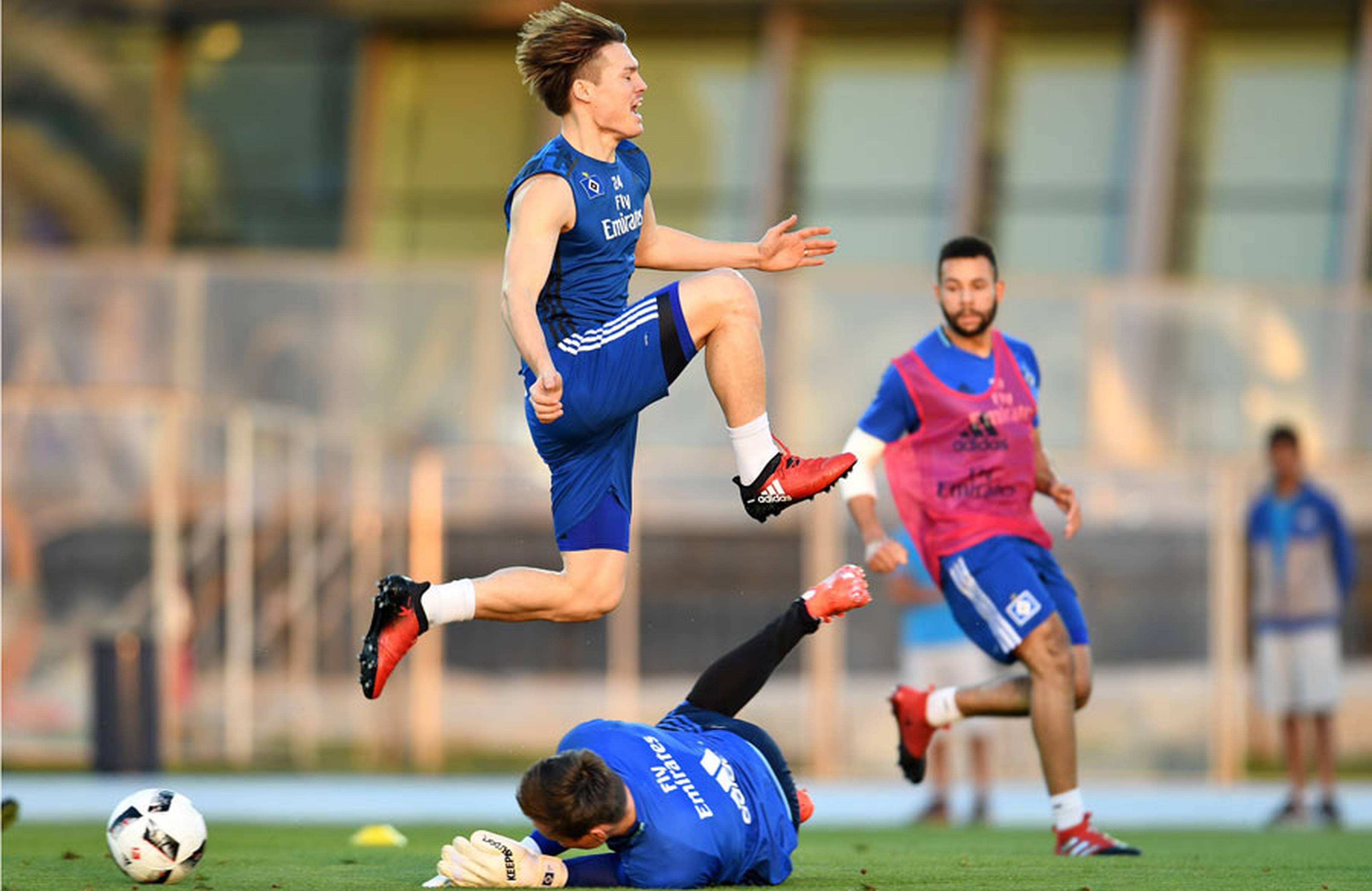 Go Sakai springt im Training über einen am Boden liegenden Spieler. 