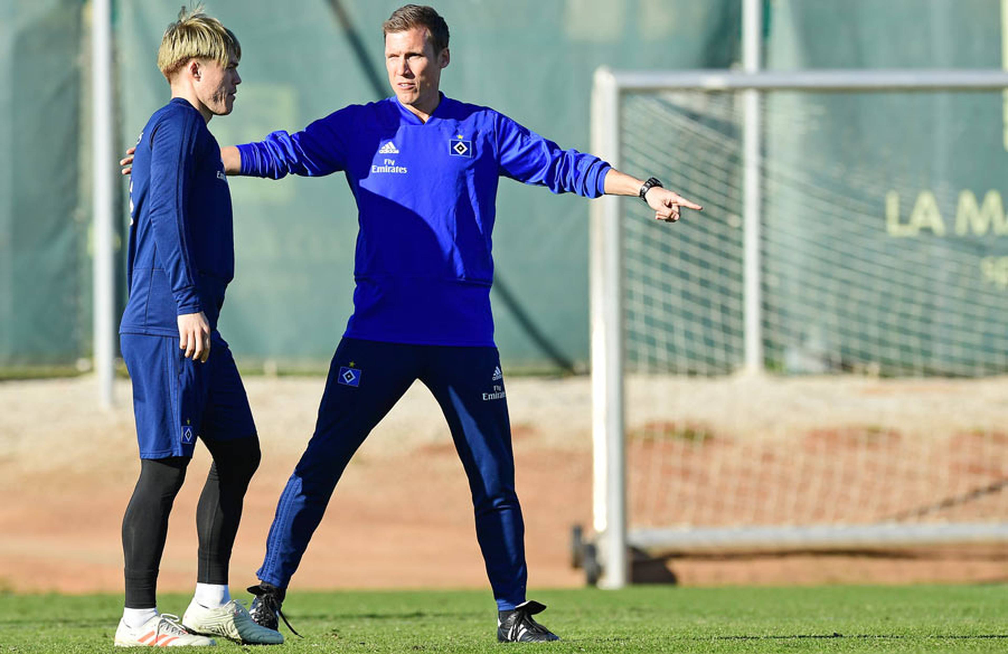 Hannes Wolfs spricht mit Go Sakai und fasst ihn an der Schulter.