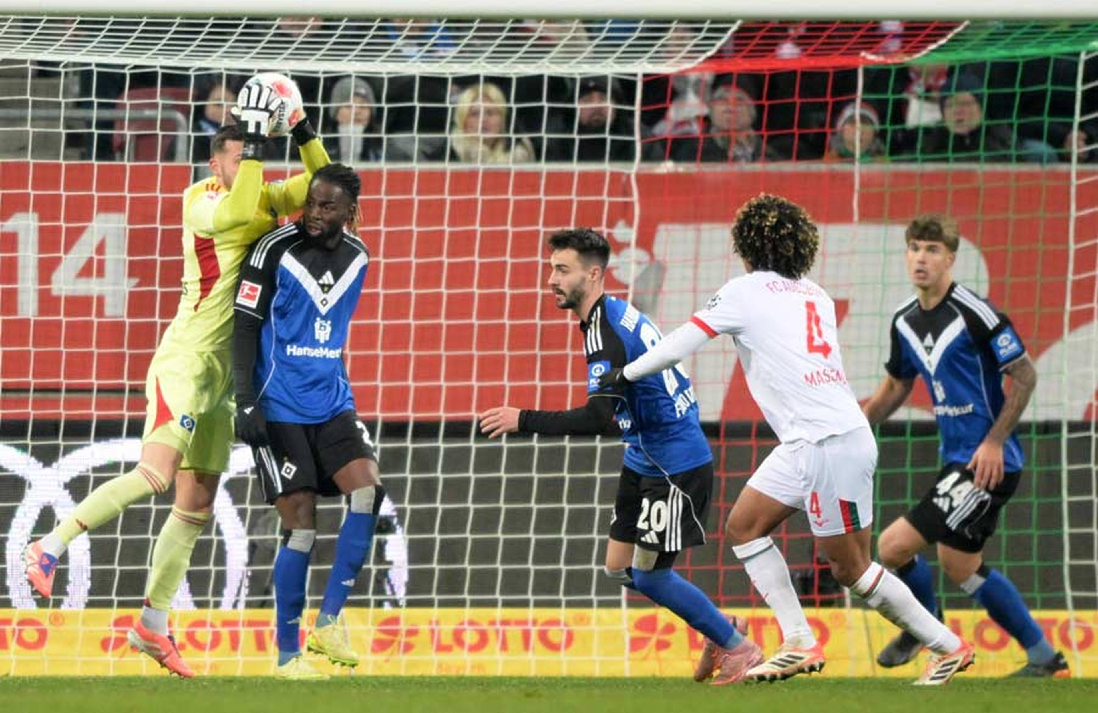 Daniel Heuer Fernandes gathers a cross in front of his defenders