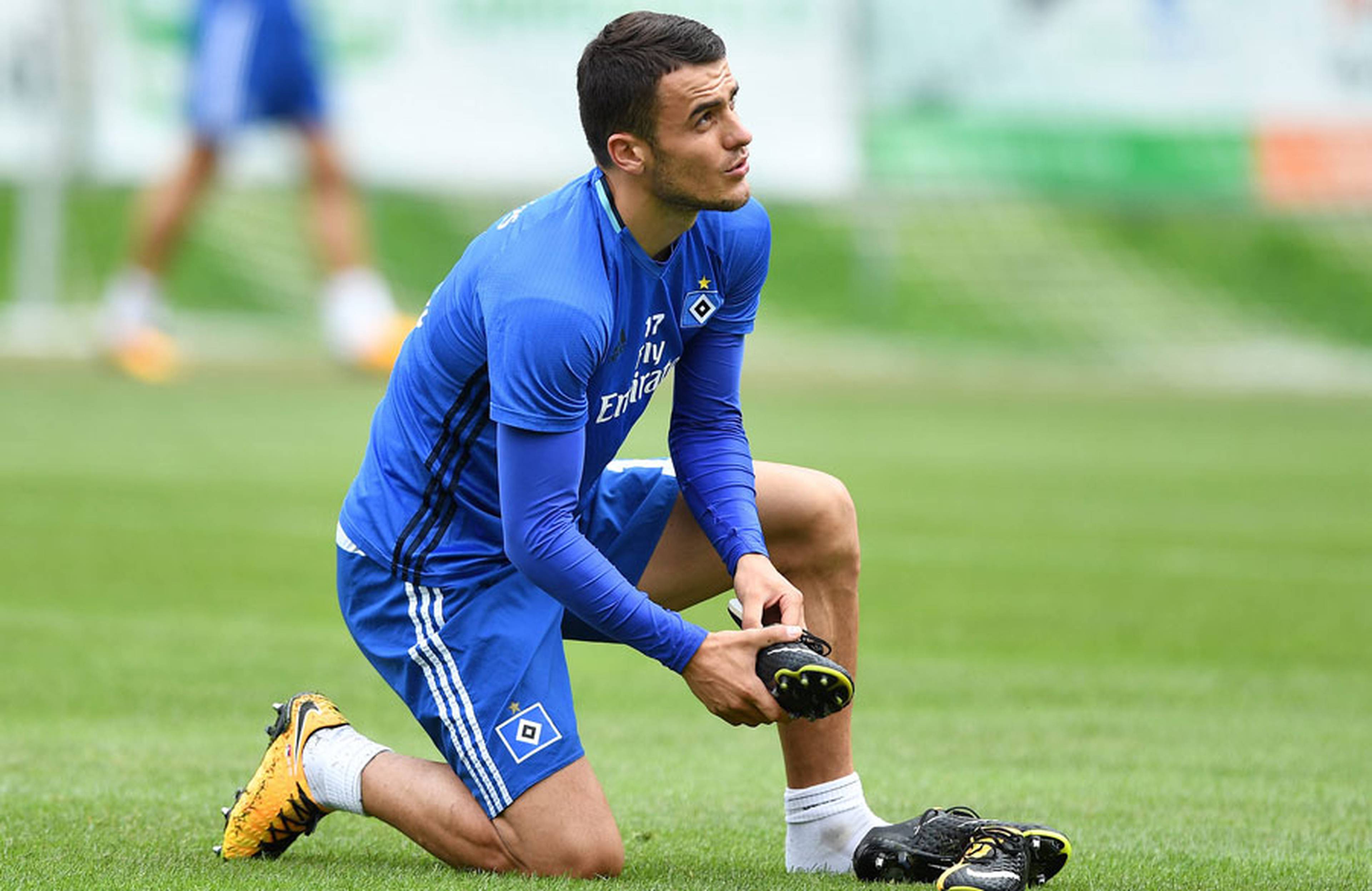 Filip Kostic schnürt sich auf dem rasen die Schuhe.