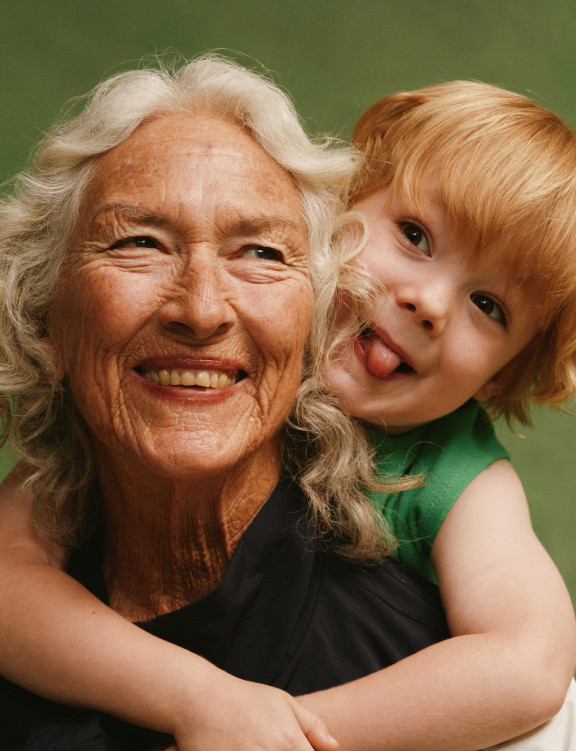 A grandmother hugging a laughing toddler