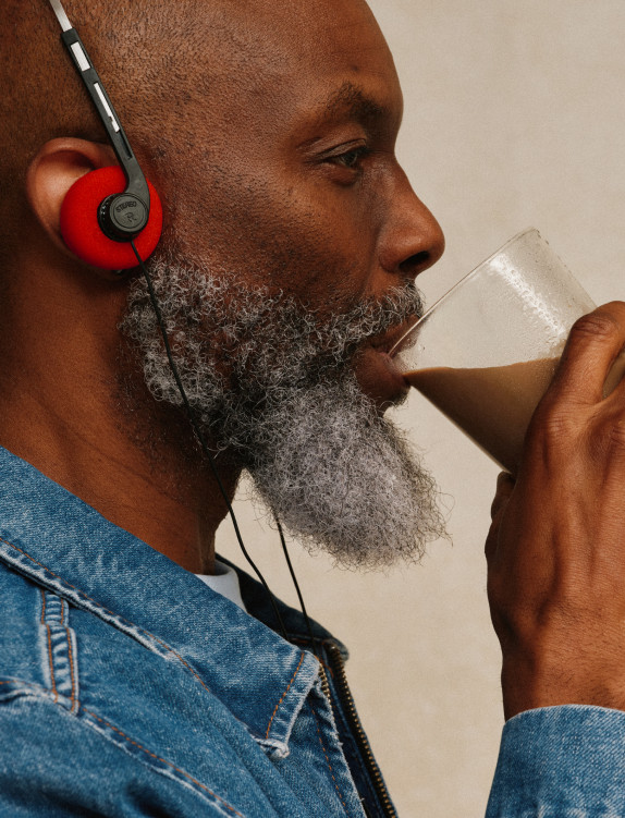 A man in red headphones drinking a Kate Farms shake