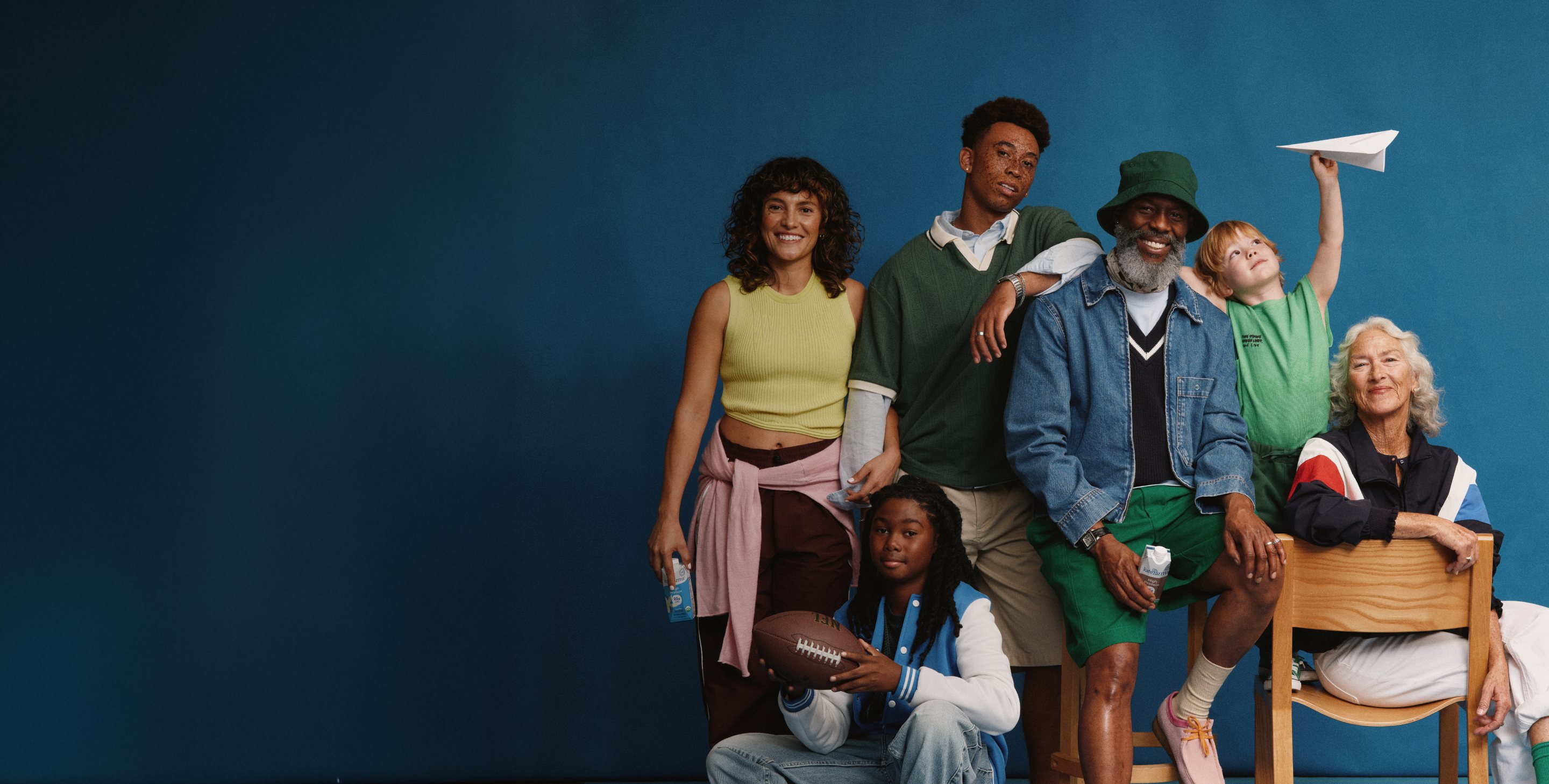 A group of Kate Farms champions of all ages posing together against a blue backdrop