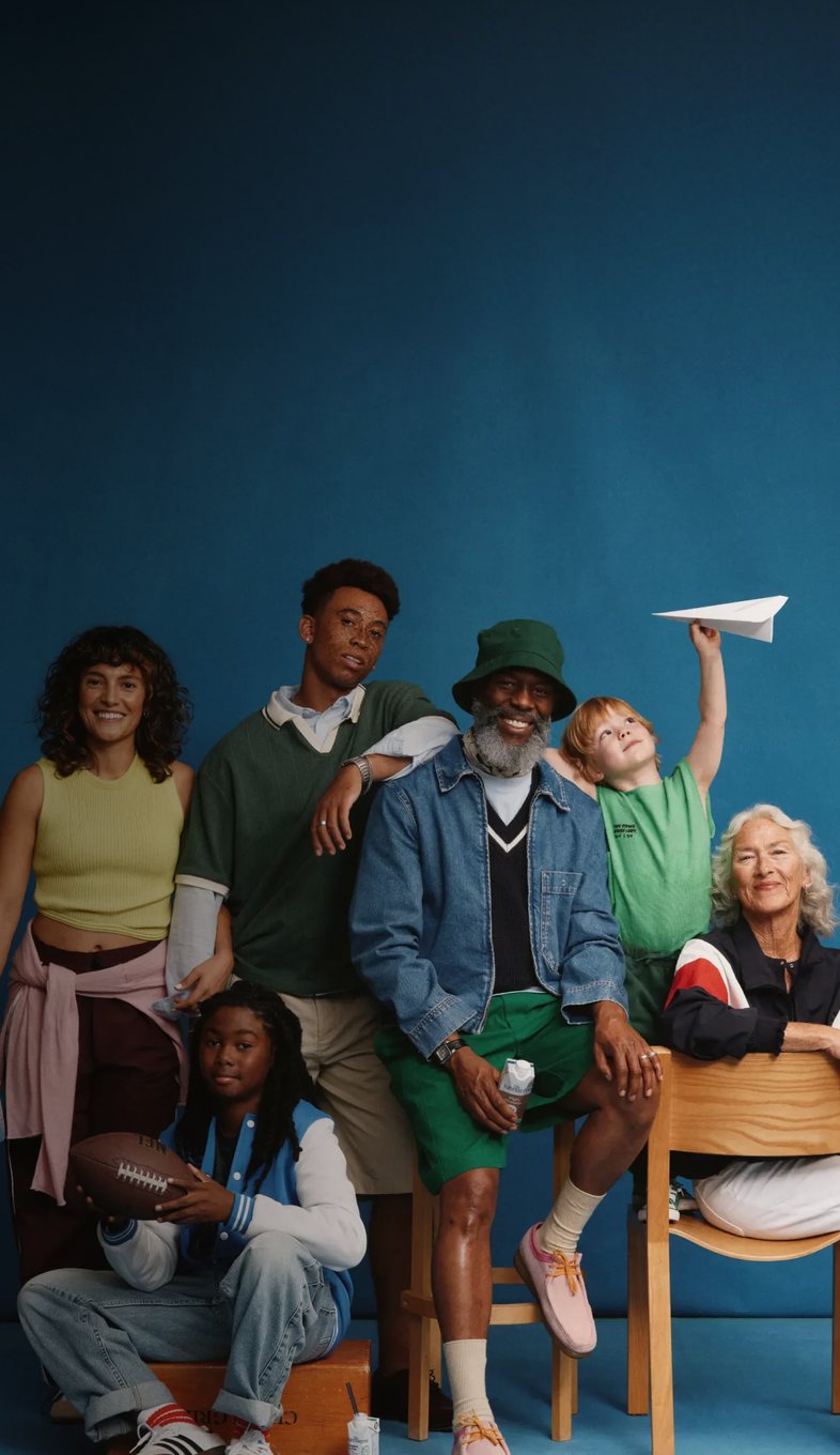 A group of Kate Farms champions of all ages posing together against a blue backdrop