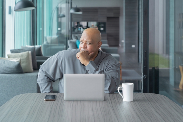 Man sitting at his desk looking out a window.