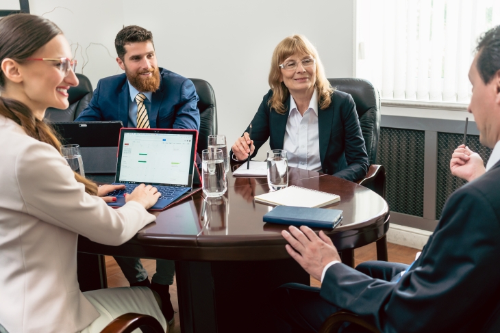 Confident Business People Smiling While Listening To Their Colleague