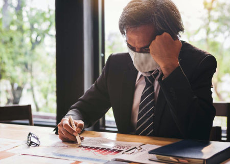 Man wearing a mask while looking at documents.