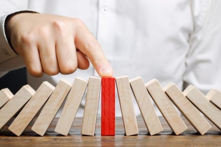 Wooden dominos falling towards a center red colored domino.