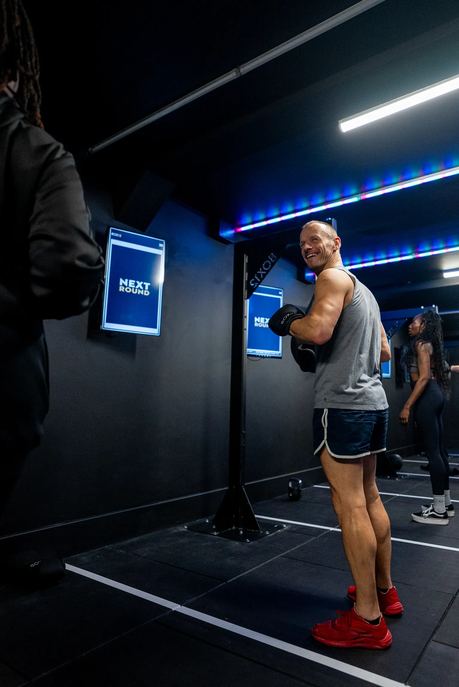 Man in boxing fitness studio with digital screens