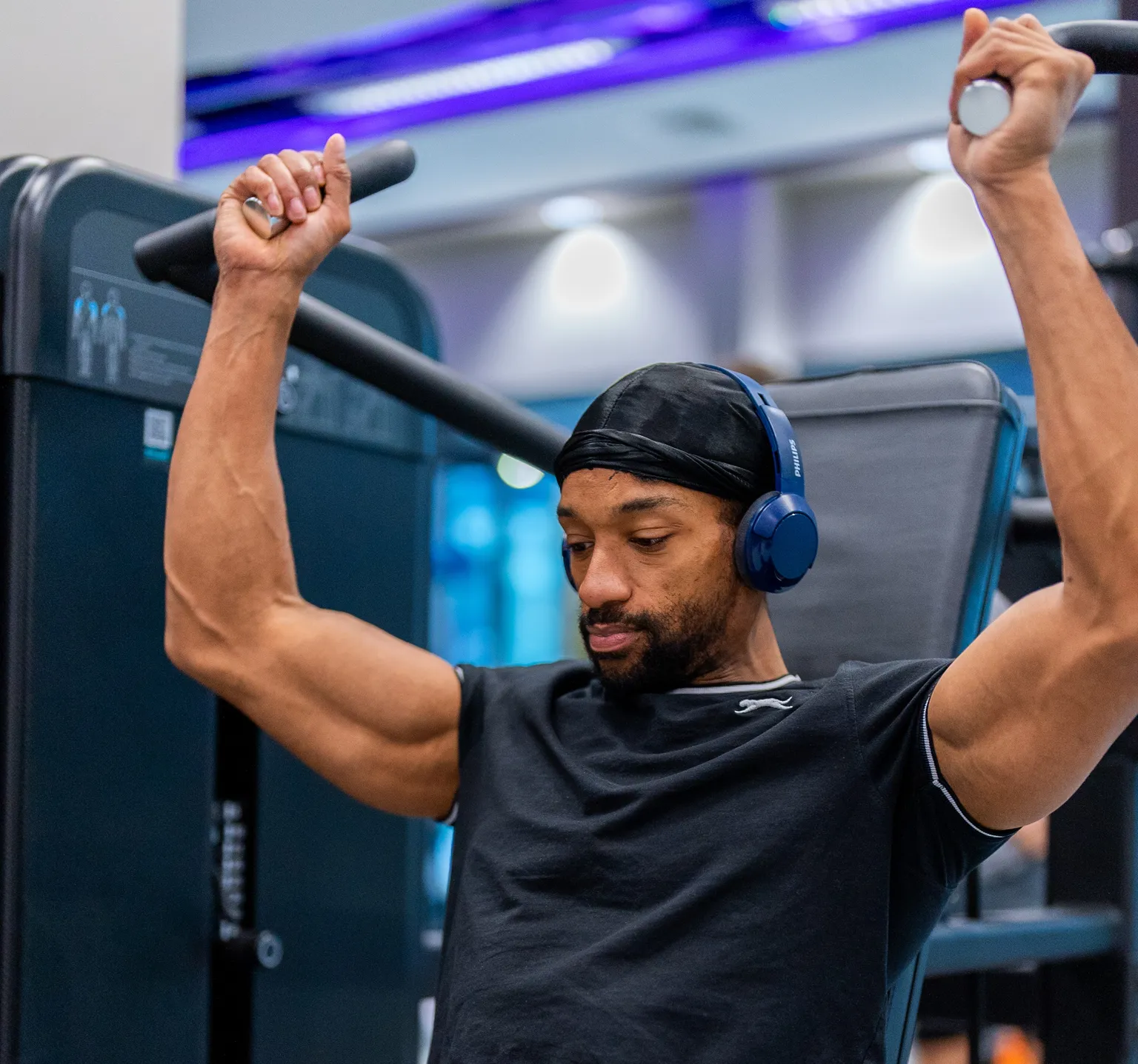 man on weight machine listening to music