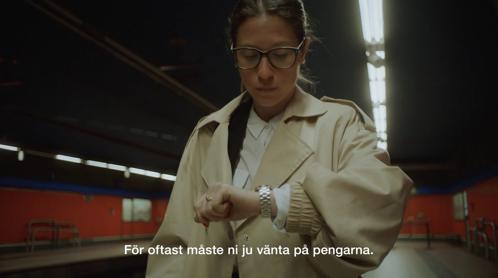 Omslagsbild till videon om Säljfinansering. Still bild från videon med kvinna som tittar på klockan.