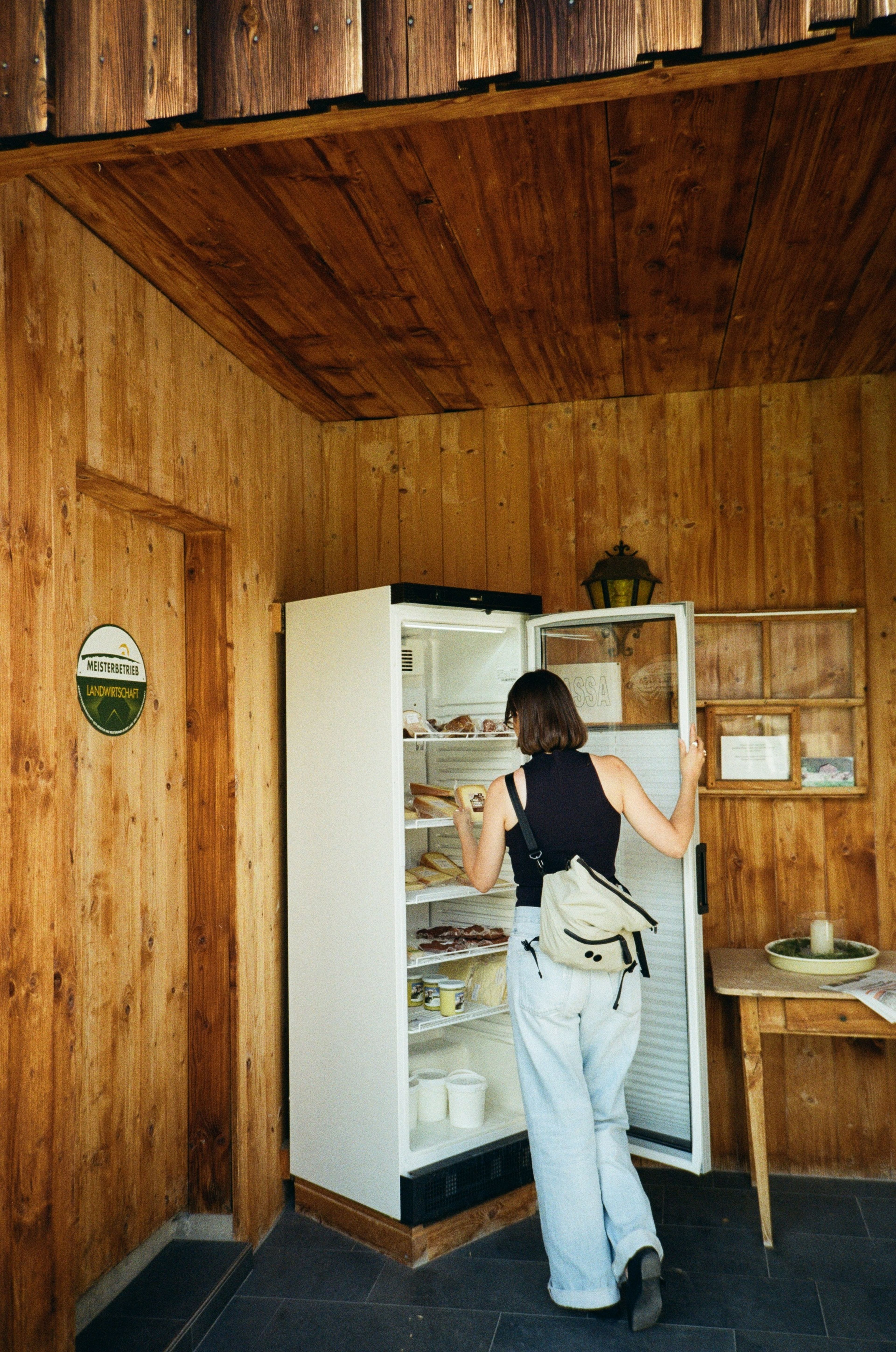 Frau nimmt Käse aus dem SB-Kühlschrank