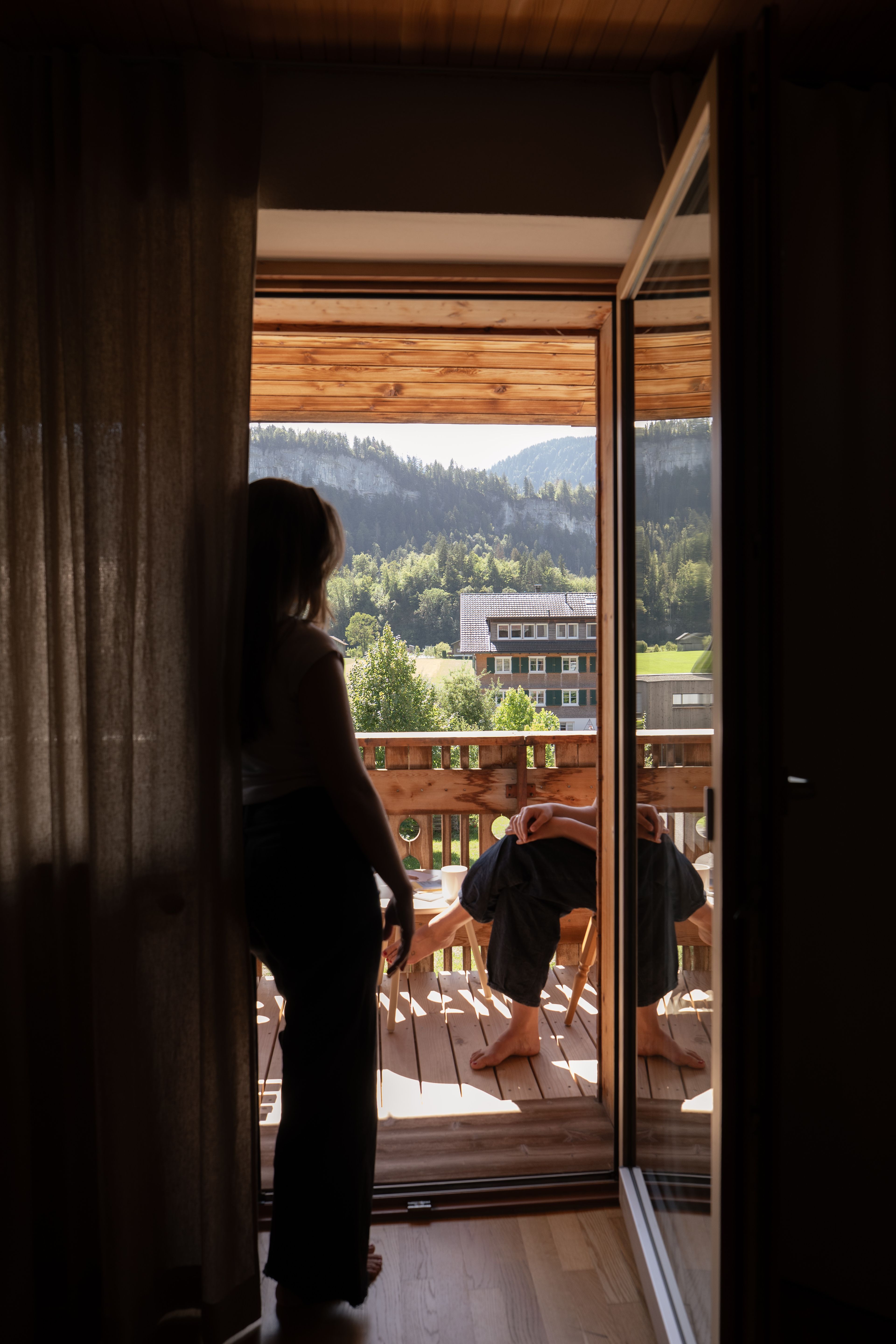 Frau steht in der Balkontüre und schaut auf den Balkon