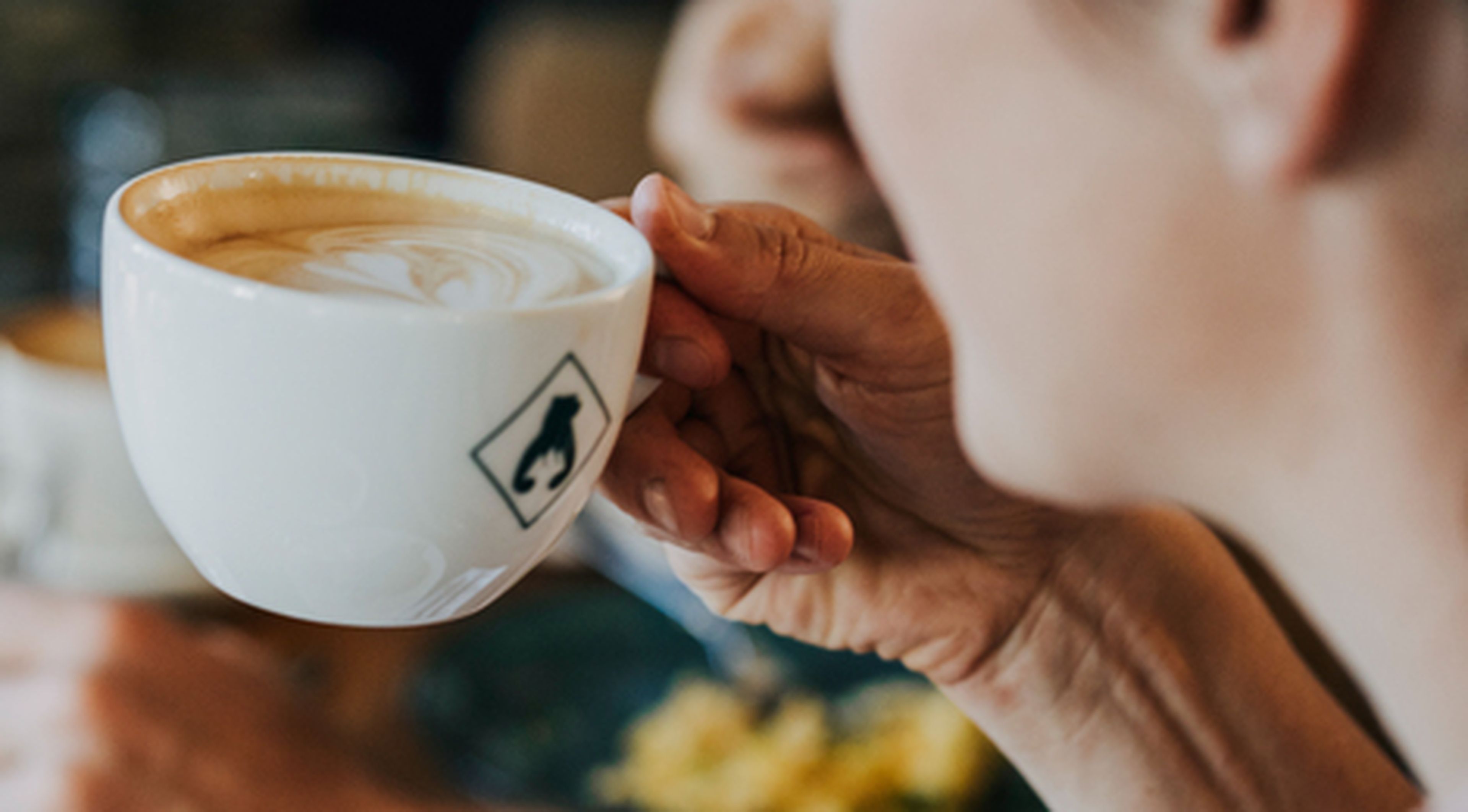 Eine Frau hält eine Tasse Kaffee in der Hand