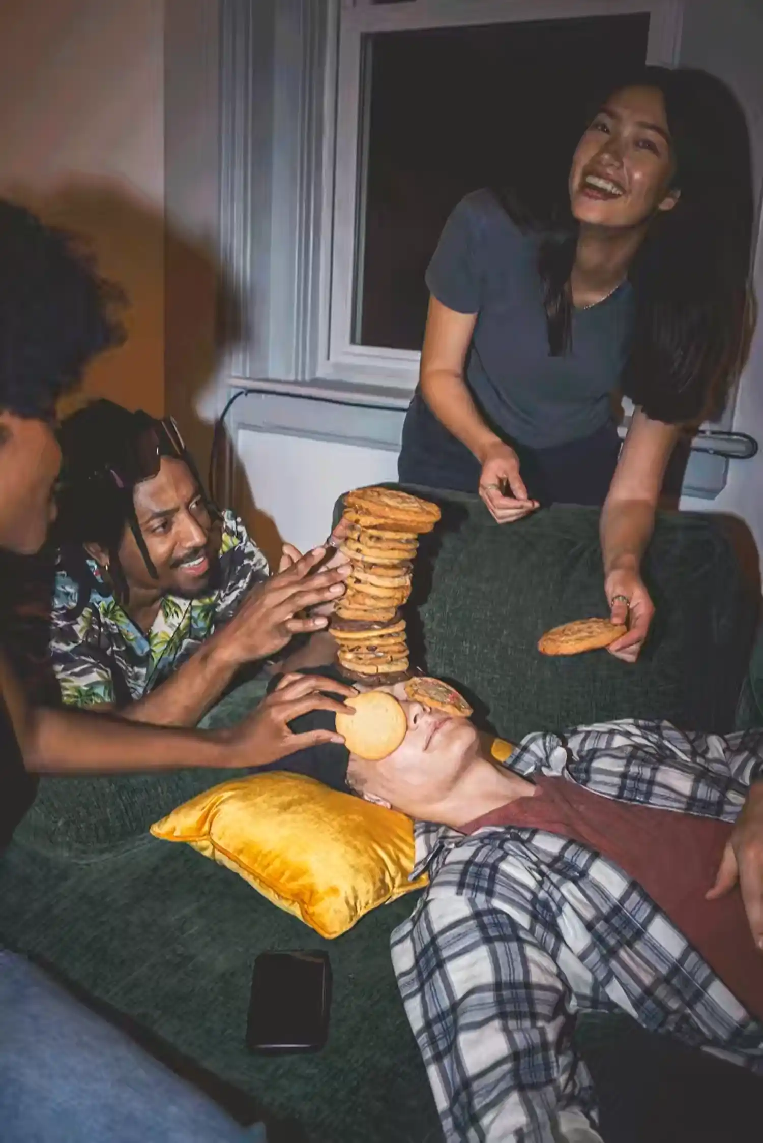 People stacking Insomnia cookies on a sleeping guys face