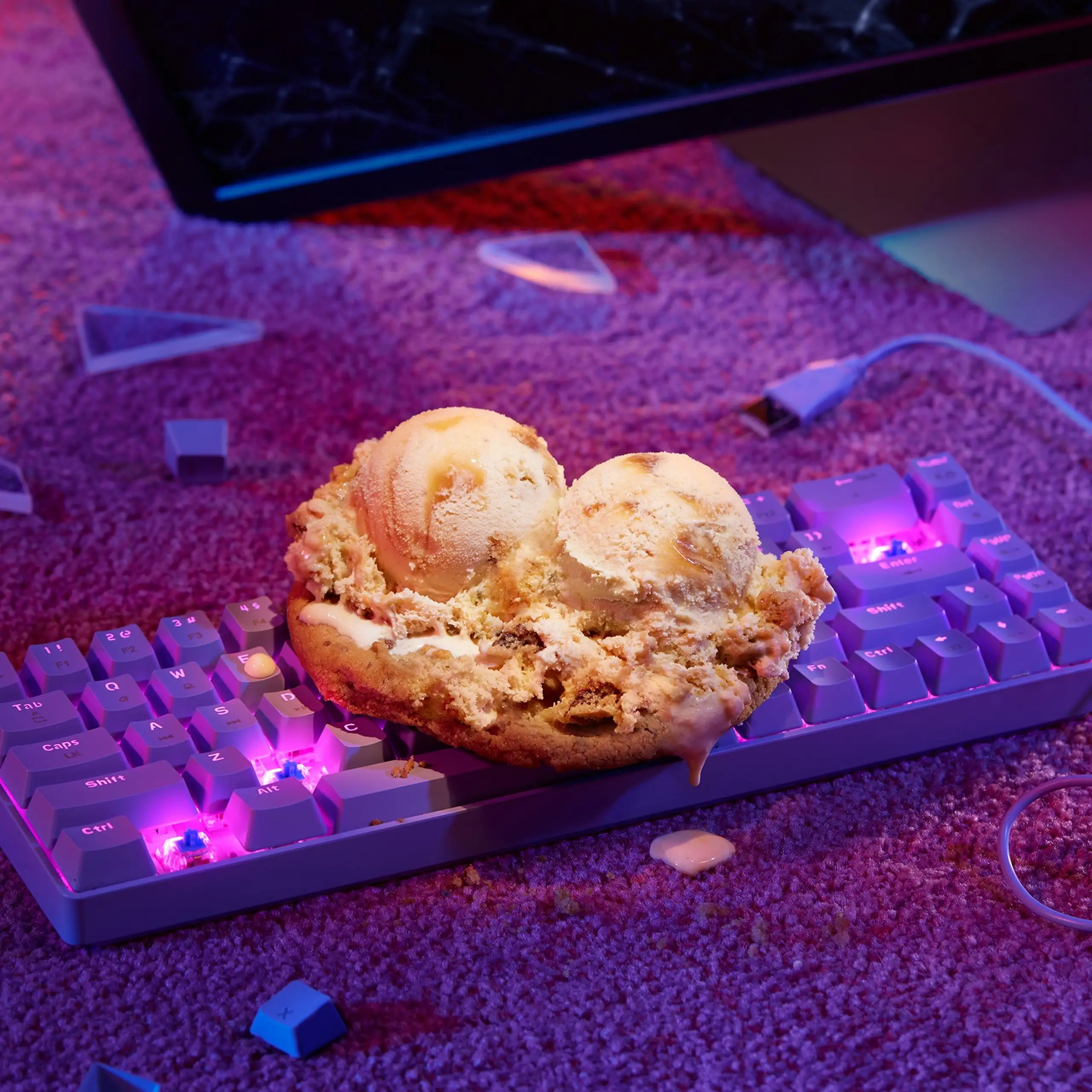 Caramel ice cream on cookies on a keyboard with a broken monitor