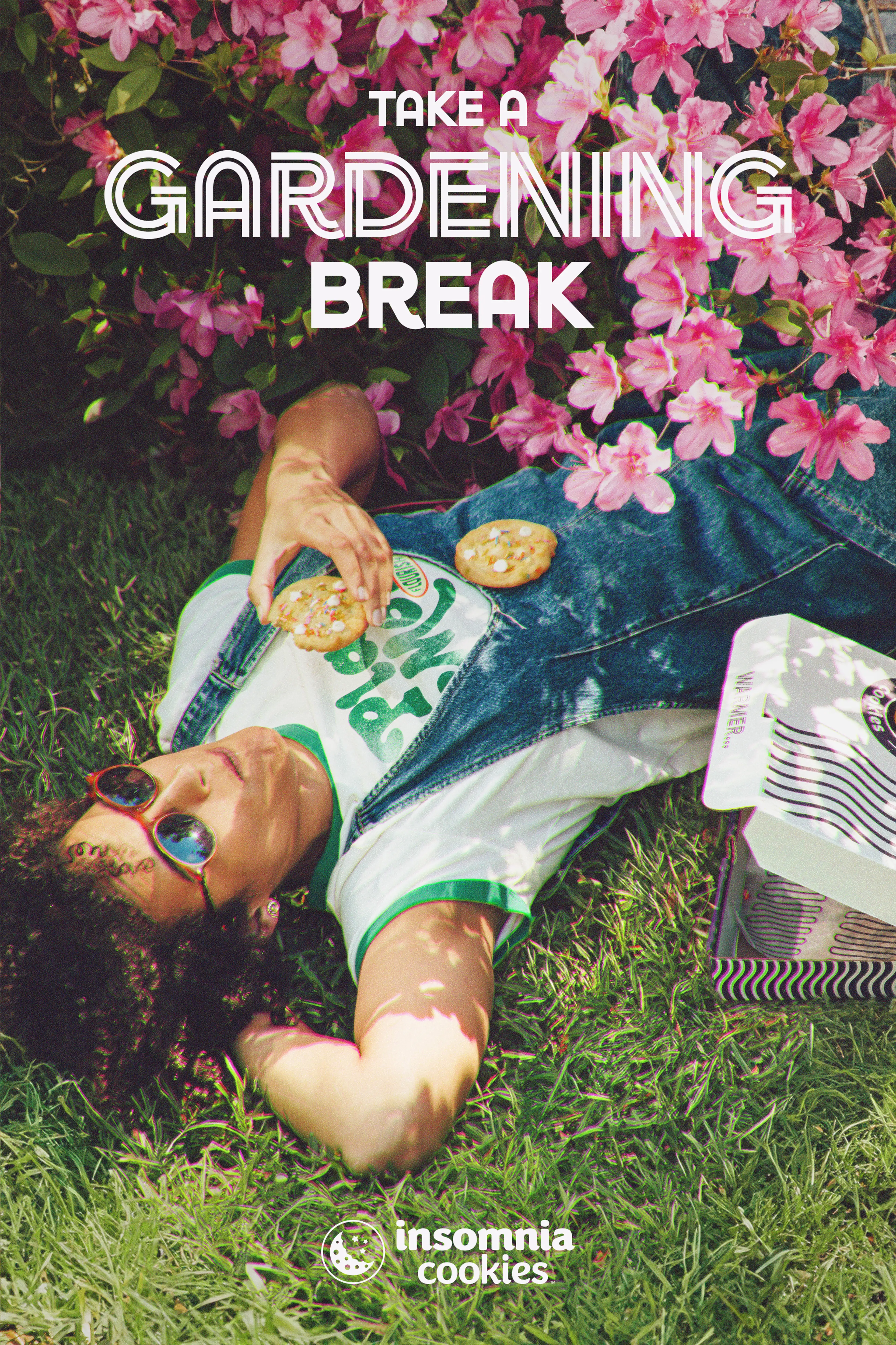 Girl relaxing on grass eating two insomnia cookies