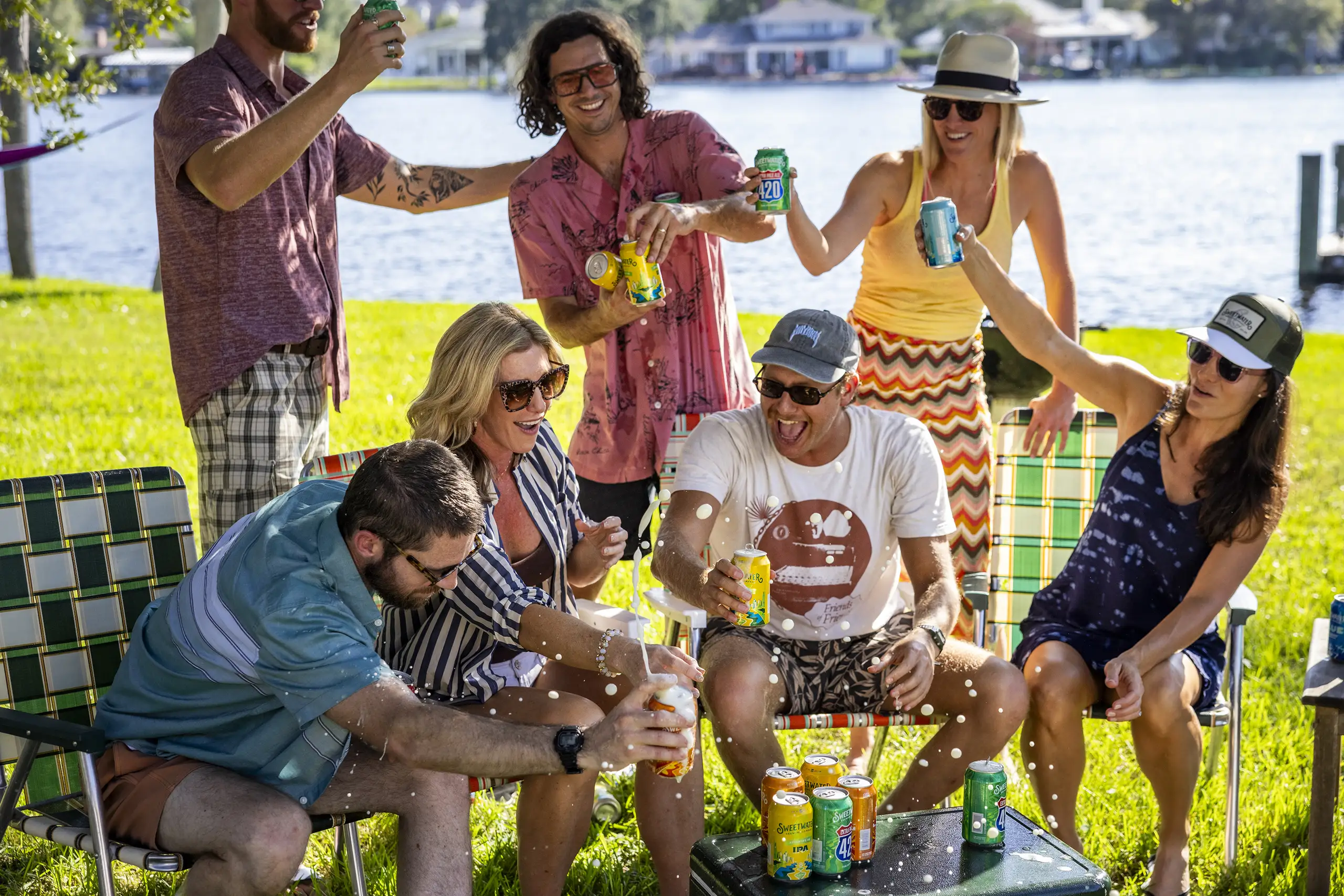 A group of people all cheersing Sweetwater drinks around a cooler.