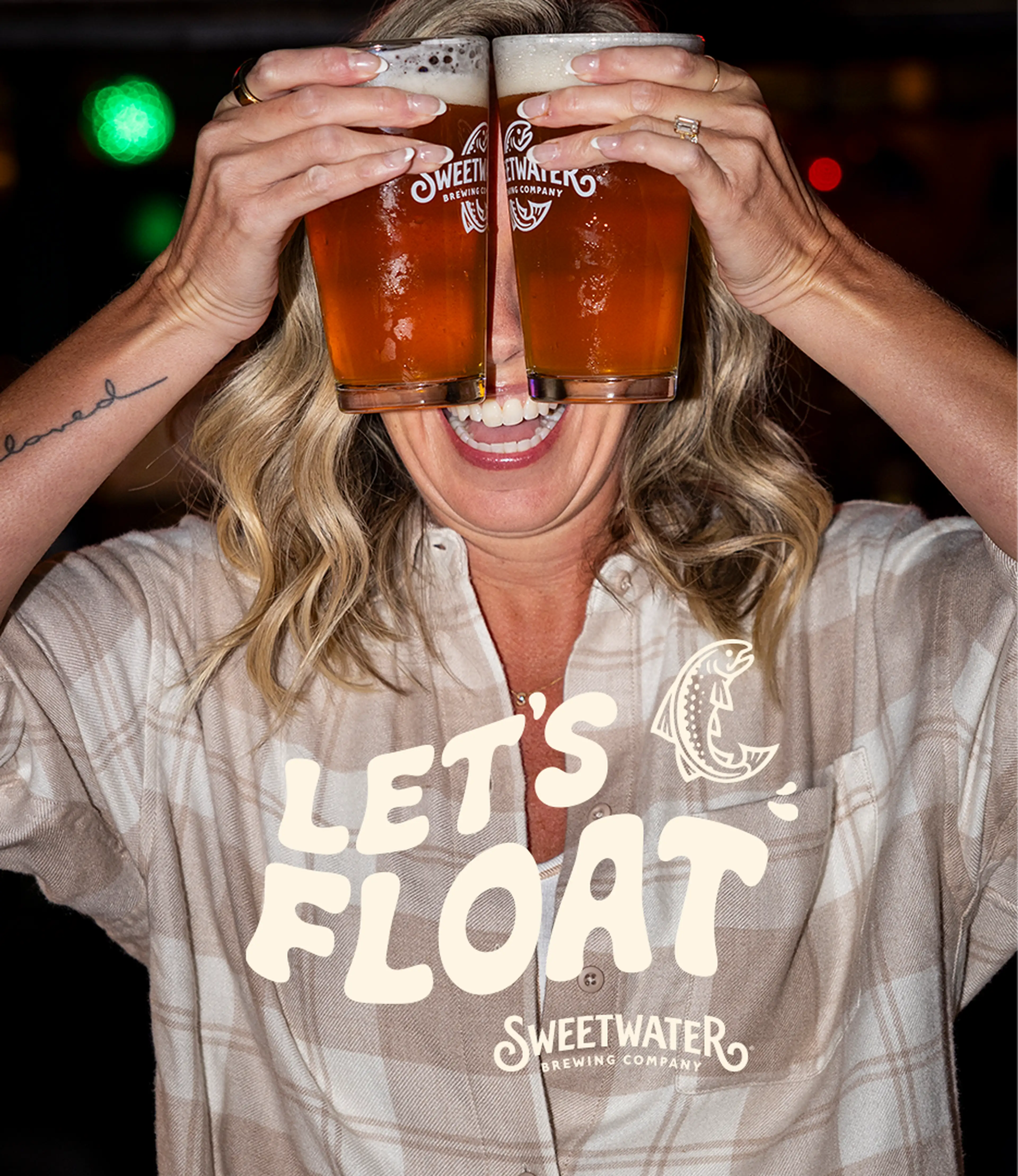 Lady holding two Sweetwater IPA beers