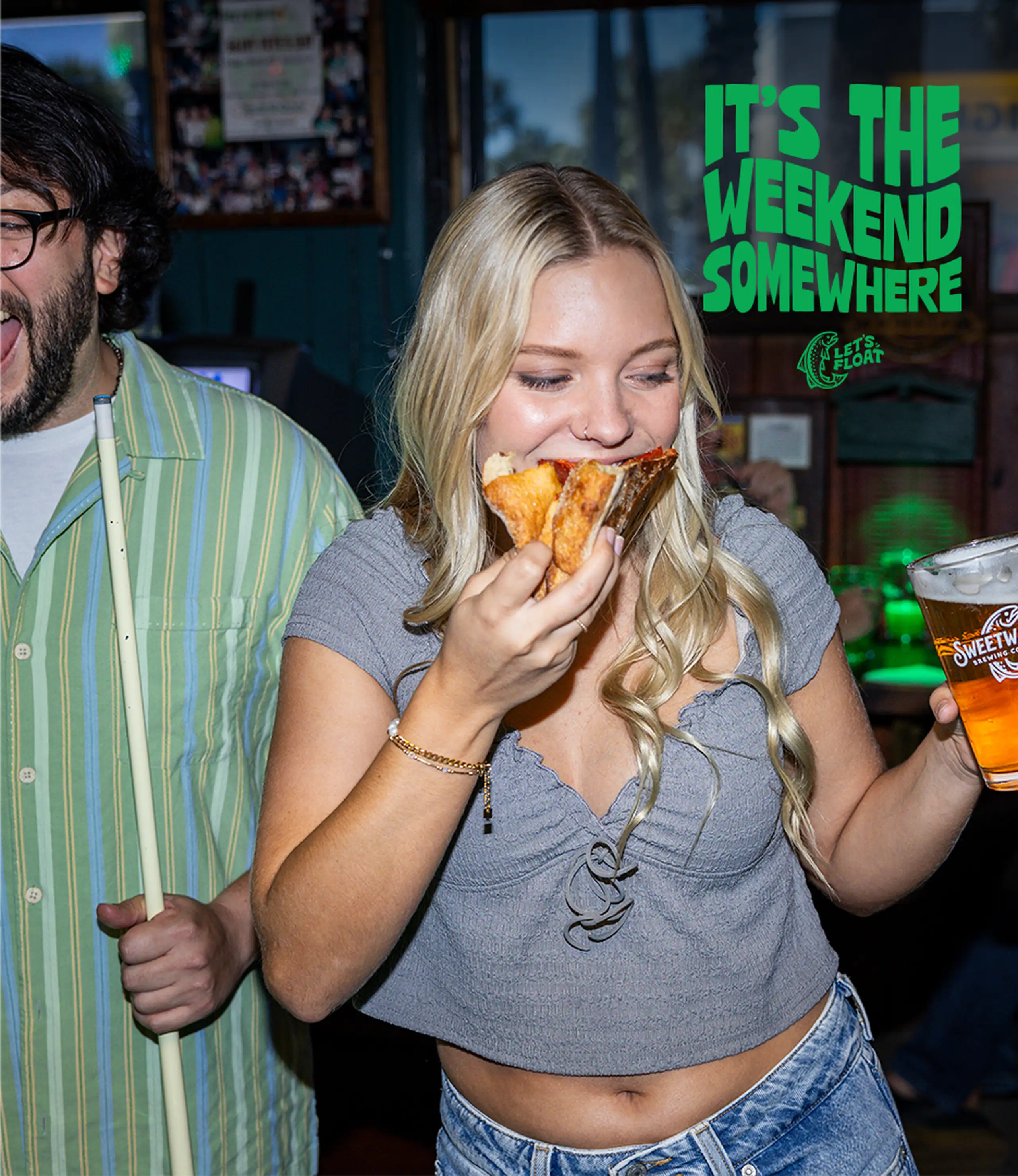 Lady holding a pizza and a Sweetwater IPA beer