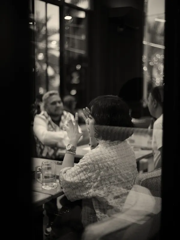 Guests dining in a luxury hotel restaurant, whilst woman speaks