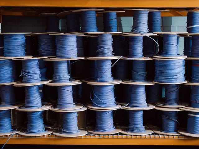 Rows of blue data cable reels on warehouse racking