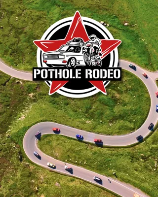 Autos vom Pothole Rodeo auf einer kurvigen Straße hinter dem Pothole Rodeo Logo.