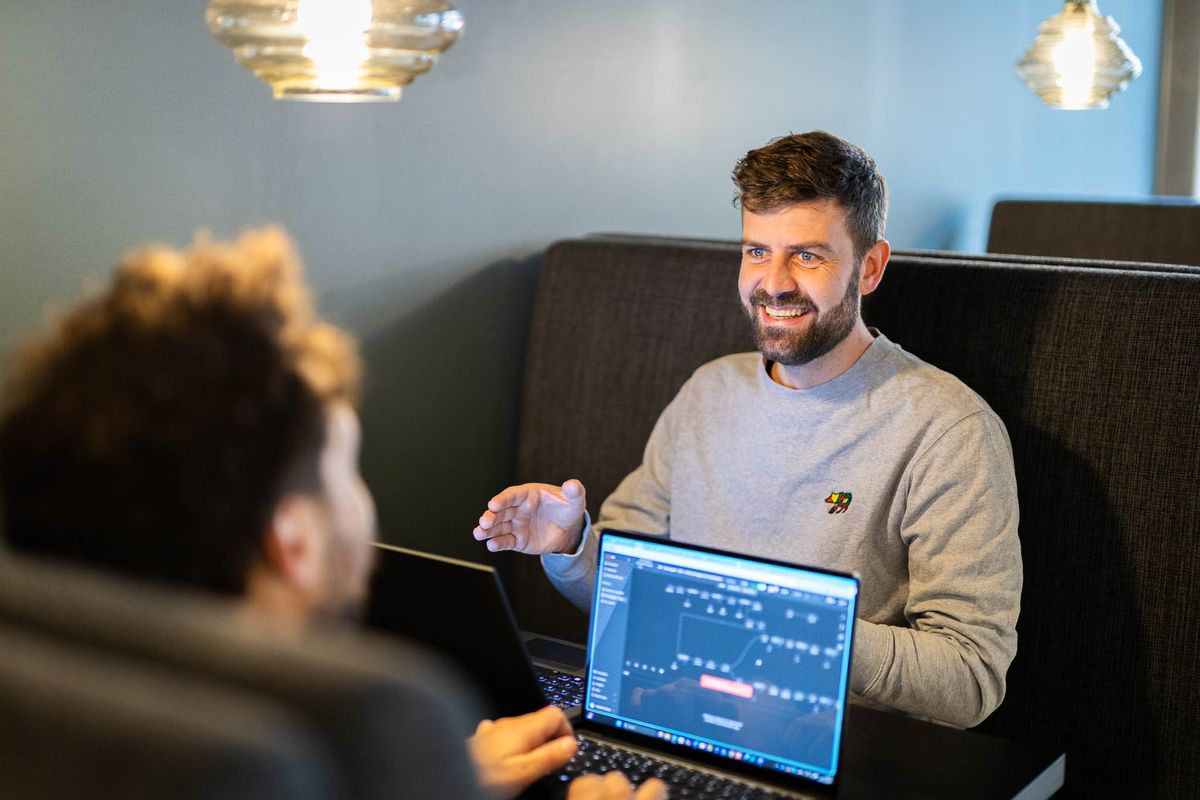 Jacob hjælper en kursist med visuelt output og struktur på Claude kursus ved laptop