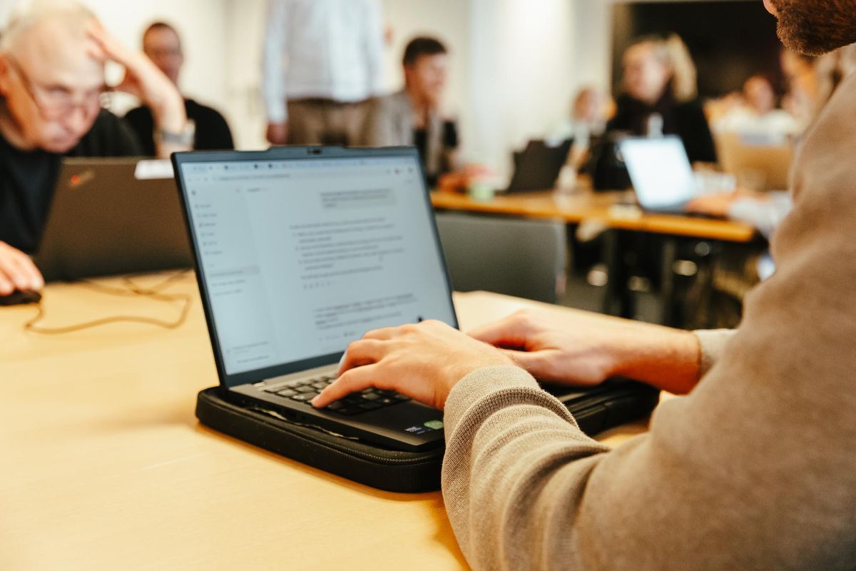 Kursister arbejder praktisk ved laptops med små opgaver og Claude Code introduktion på kursus