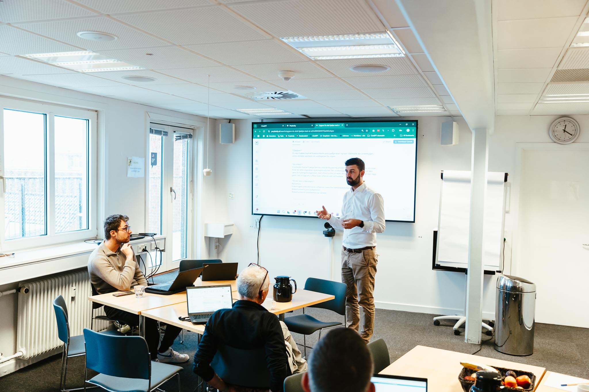 Jacob underviser deltagere med laptops på Claude kursus i et lyst kursuslokale hos HverdagsAI