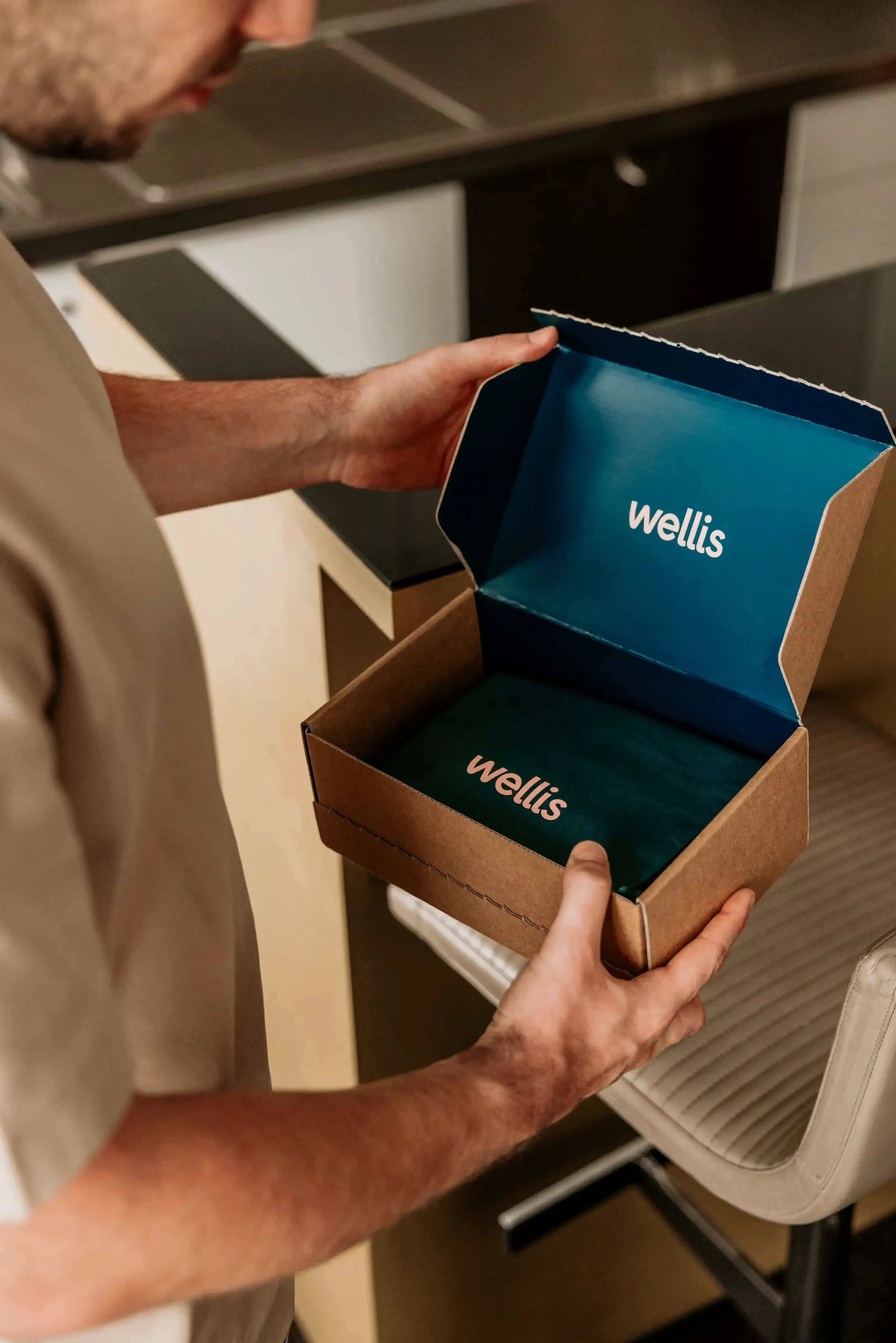 Man opent in zijn keuken een Wellis-verzenddoos met zijn behandeling