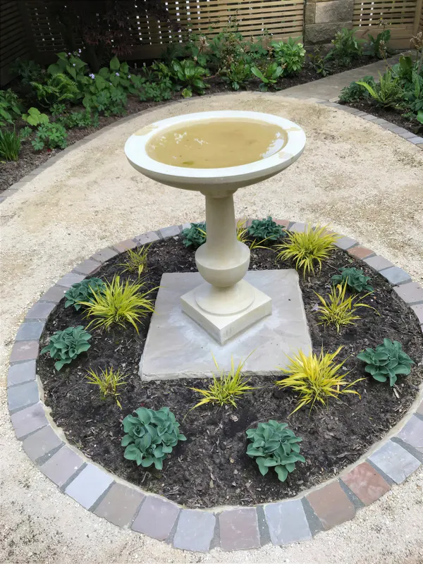 A formal circular water feature surrounded by planting